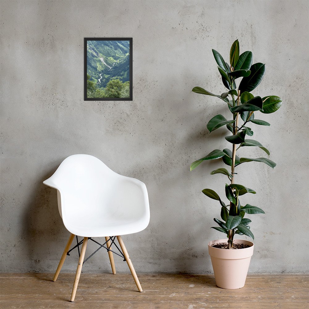 Grüner Einschnitt im schwarzen Rahmen über einem weissen Stuhl neben einer Pflanze. Raumvisualisierung / A green opening, framed photograph shown in a room mockup.