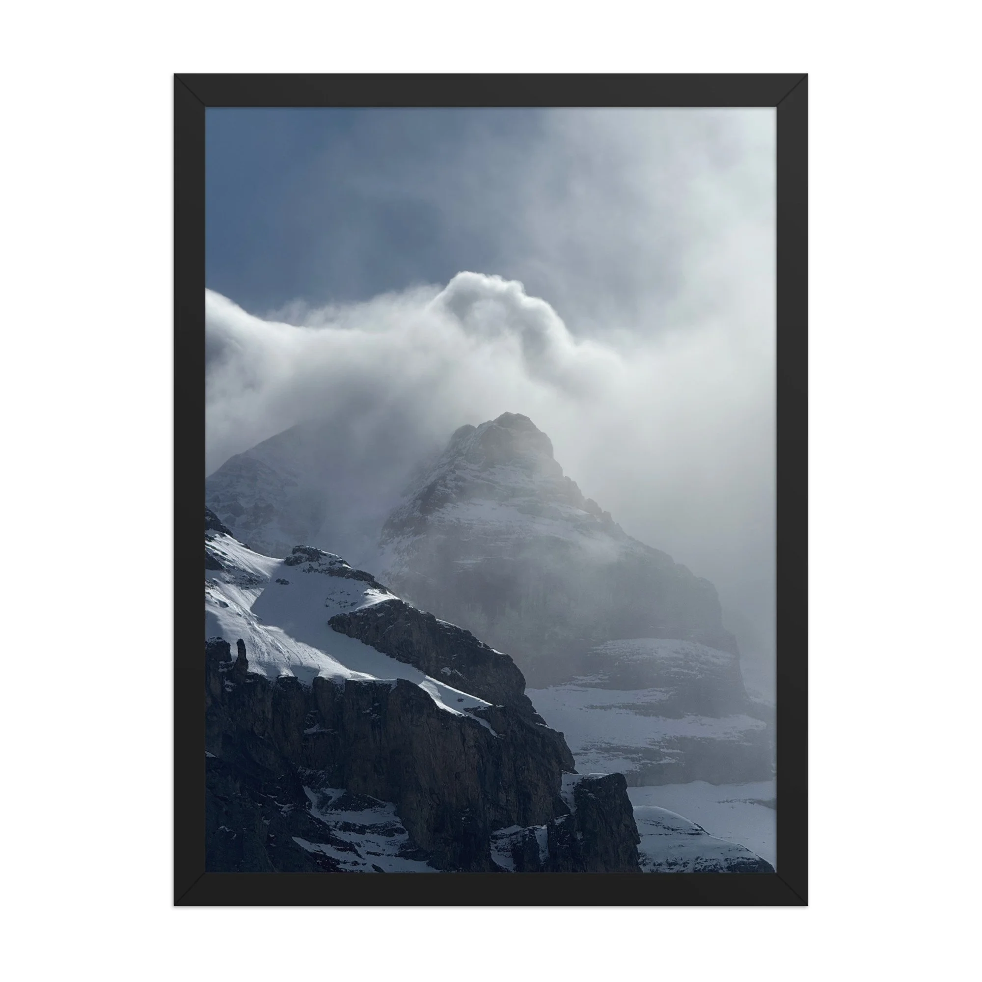 Bergspitze zwischen Schnee und Wolken, schwarzer Rahmen. Mountain peak in cloud, black frame.