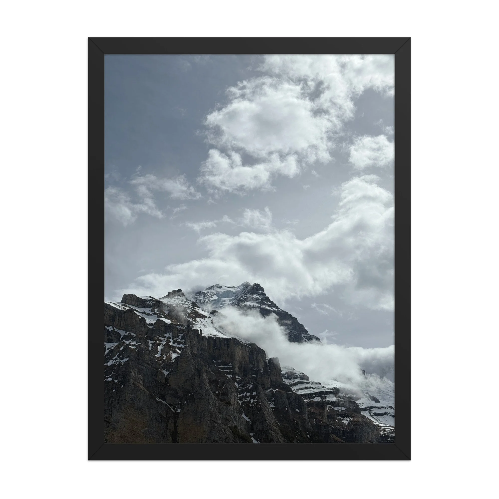 Wolken und Schnee auf gestuften Felsen, schwarzer Rahmen. Clouds over snow-covered rock, black frame.