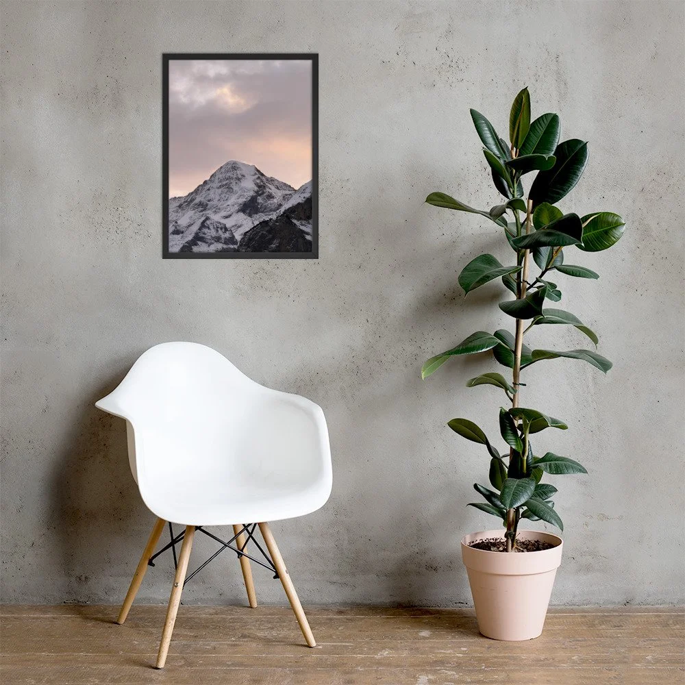 Wintergluehen im schwarzen Rahmen mit Stuhl und Pflanze. Framed mountain photograph; room mockup.