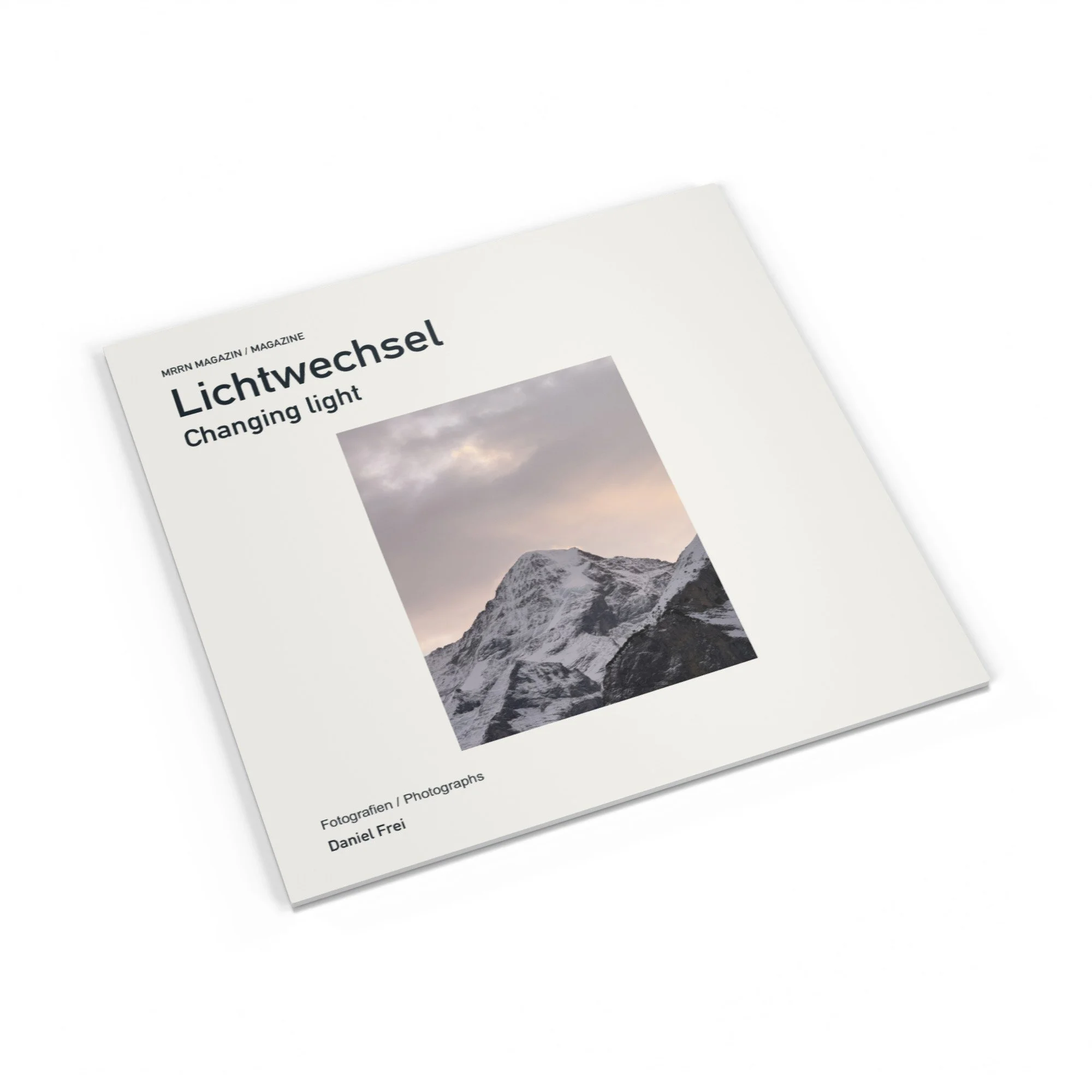 Lichtwechsel-Magazin, matter Umschlag mit Winterglühen. Changing light magazine, matte cover with a snowy mountain photograph.