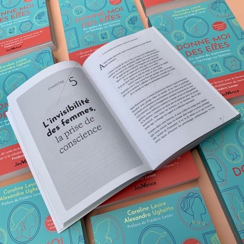 Un livre ouvert sur la page présentant le chapitre 5, intitulé "L'invisibilité des femmes : la prise de conscience", entouré de plusieurs autres livres empilés, aux couvertures bleues et rouges, portant le même titre "Donne-moi des Erres".