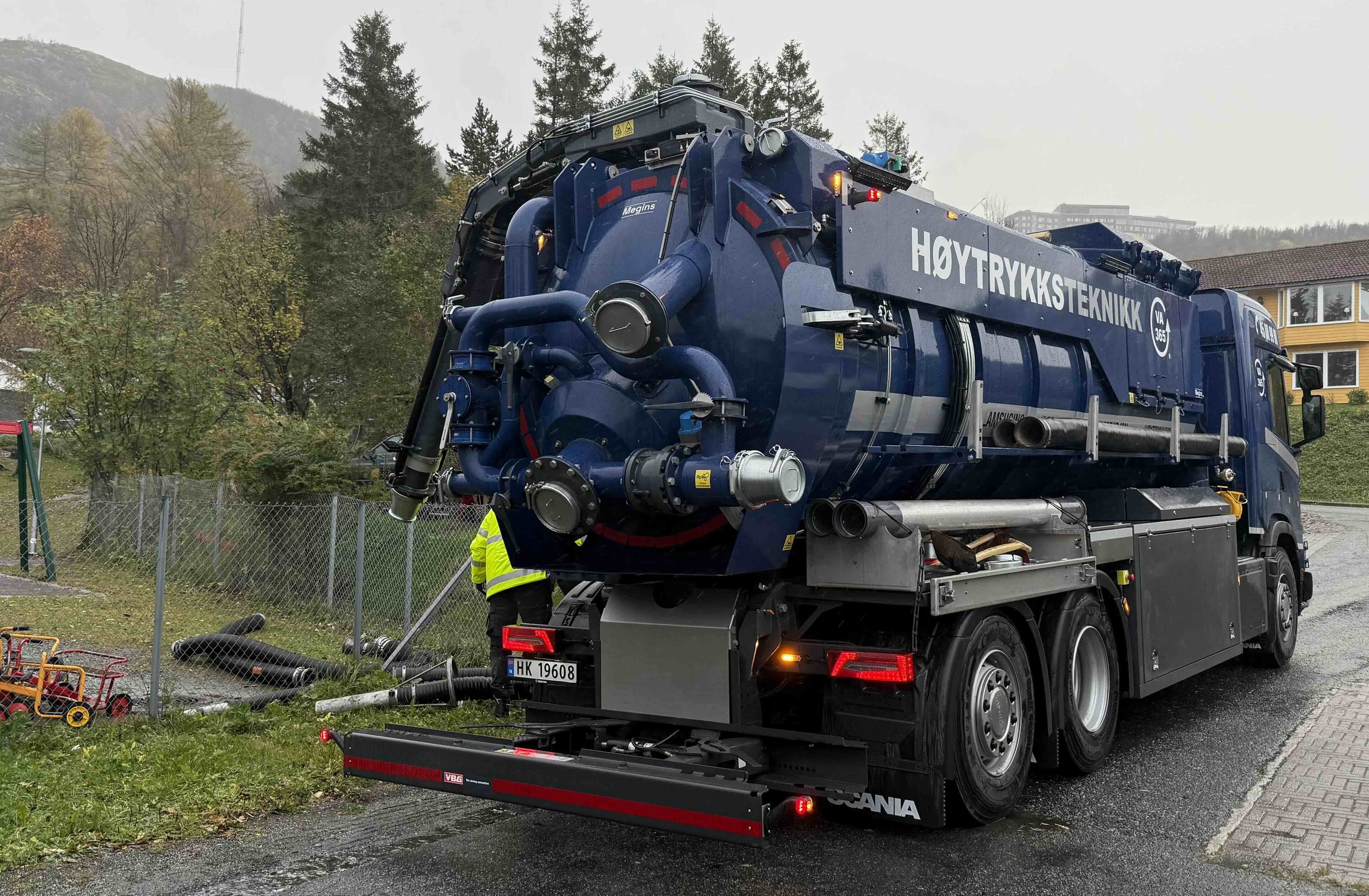 En blå vakuumlastare från Megins med texten 'Høytrykksteknikk'.