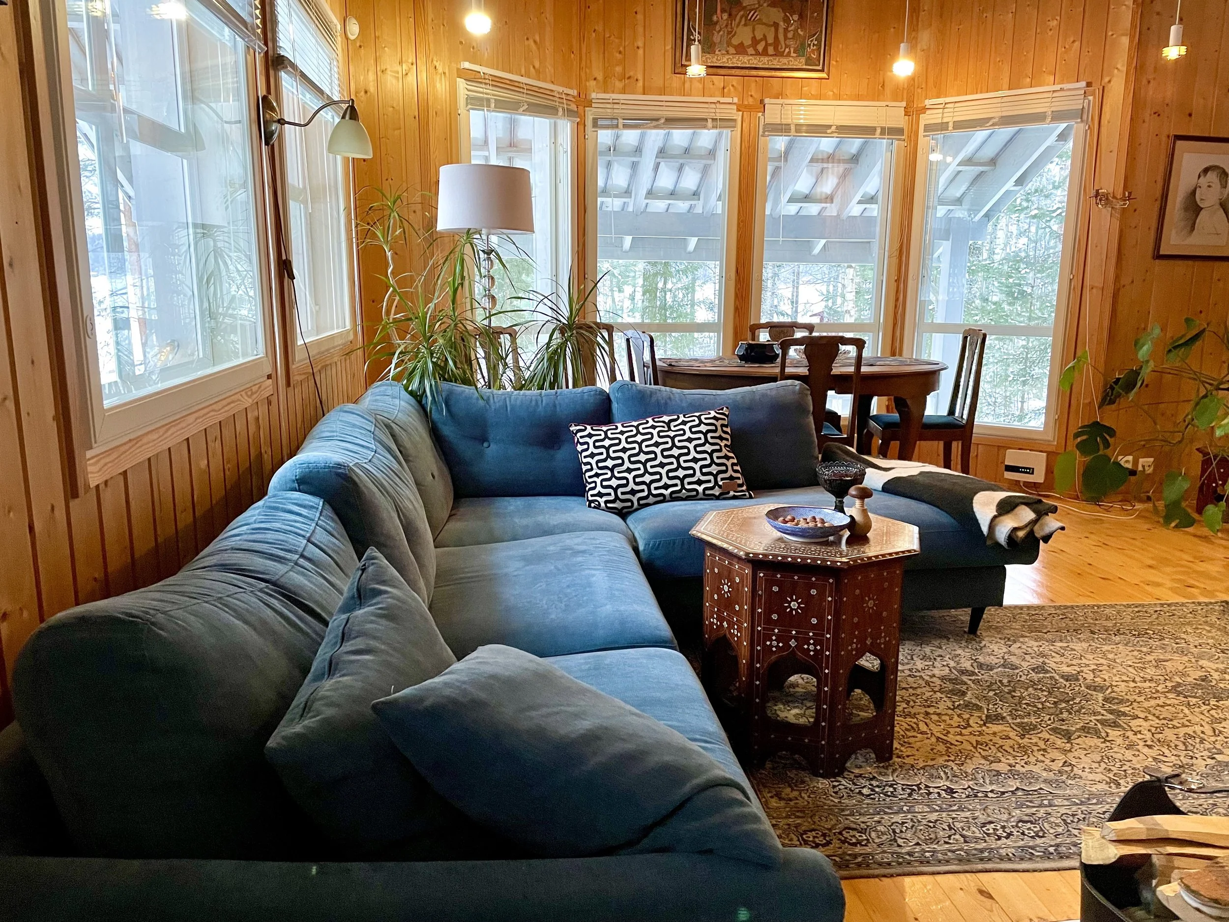 Blueberry villa living room has a cozy elegant sofa setting, fireplace, record player, modern TV and dining table by the window.