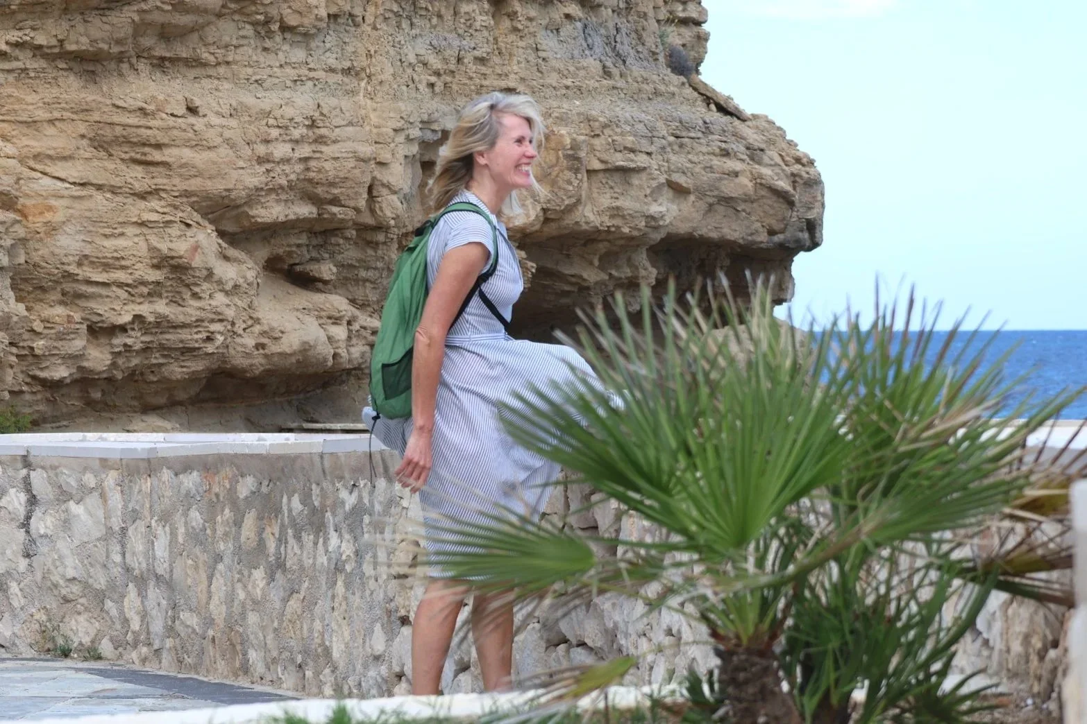 A woman walking mindfully by the sea, reflecting during a transformative travel journey back to herself