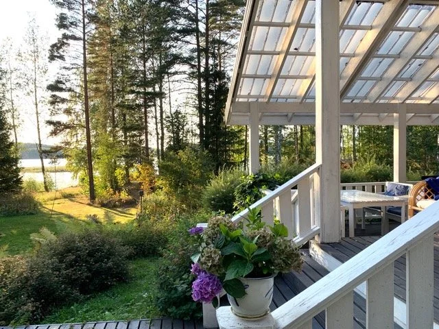 Peaceful lakeside porch at Blueberry Villa with views of forest and Lake Saimaa, setting for Finnish Happiness Camp nature retreats.