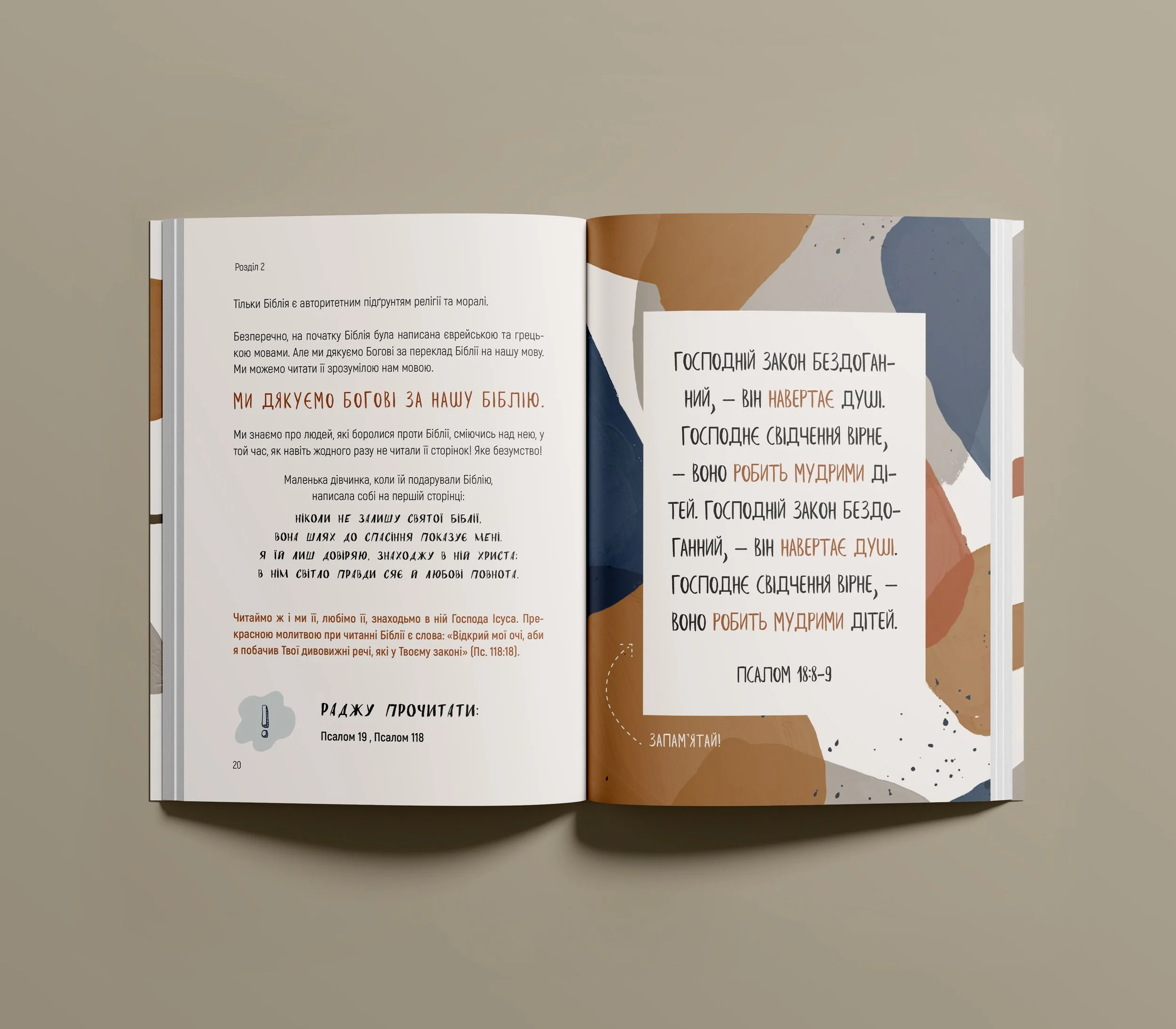 Offenes Buch auf einem Tisch mit Text auf Ukrainisch und bunter grafischer Gestaltung auf der rechten Seite. Die linke Seite enthält einen mehrsprachigen Abschnitt mit kyrillischem Text und einem Hinweis zur Bibellese. Die rechte Seite zeigt einen dekorativen Bereich mit abstrakten Farben und kyrillischem Text, möglicherweise ein religiöses Zitat oder eine Passage.
