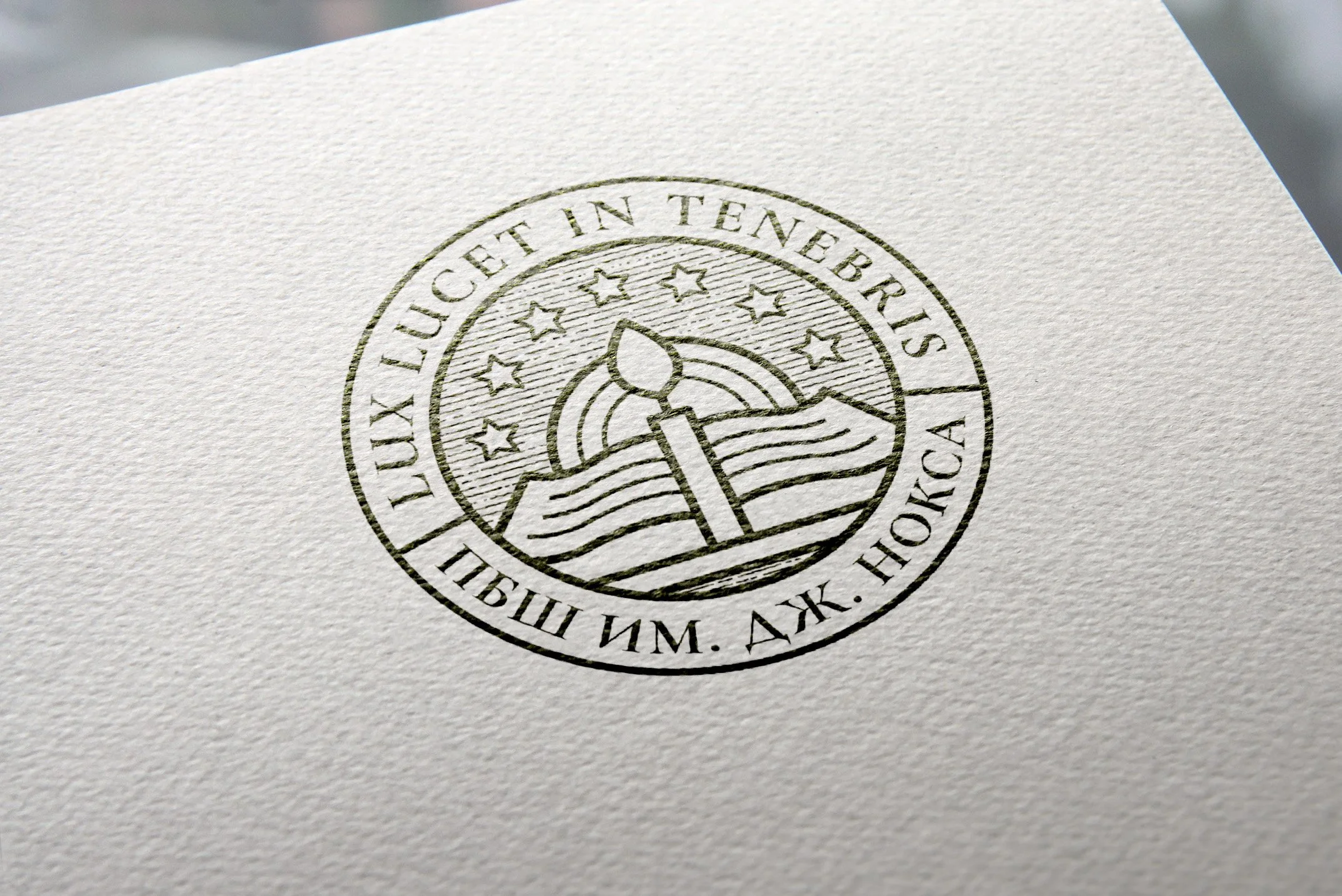 Ein geprägtes Siegel mit der Inschrift "LUX LUCET IN TENEBRIS" und kyrillischen Buchstaben. Das Design zeigt ein offenes Buch, eine Kerzenflamme und Sterne.