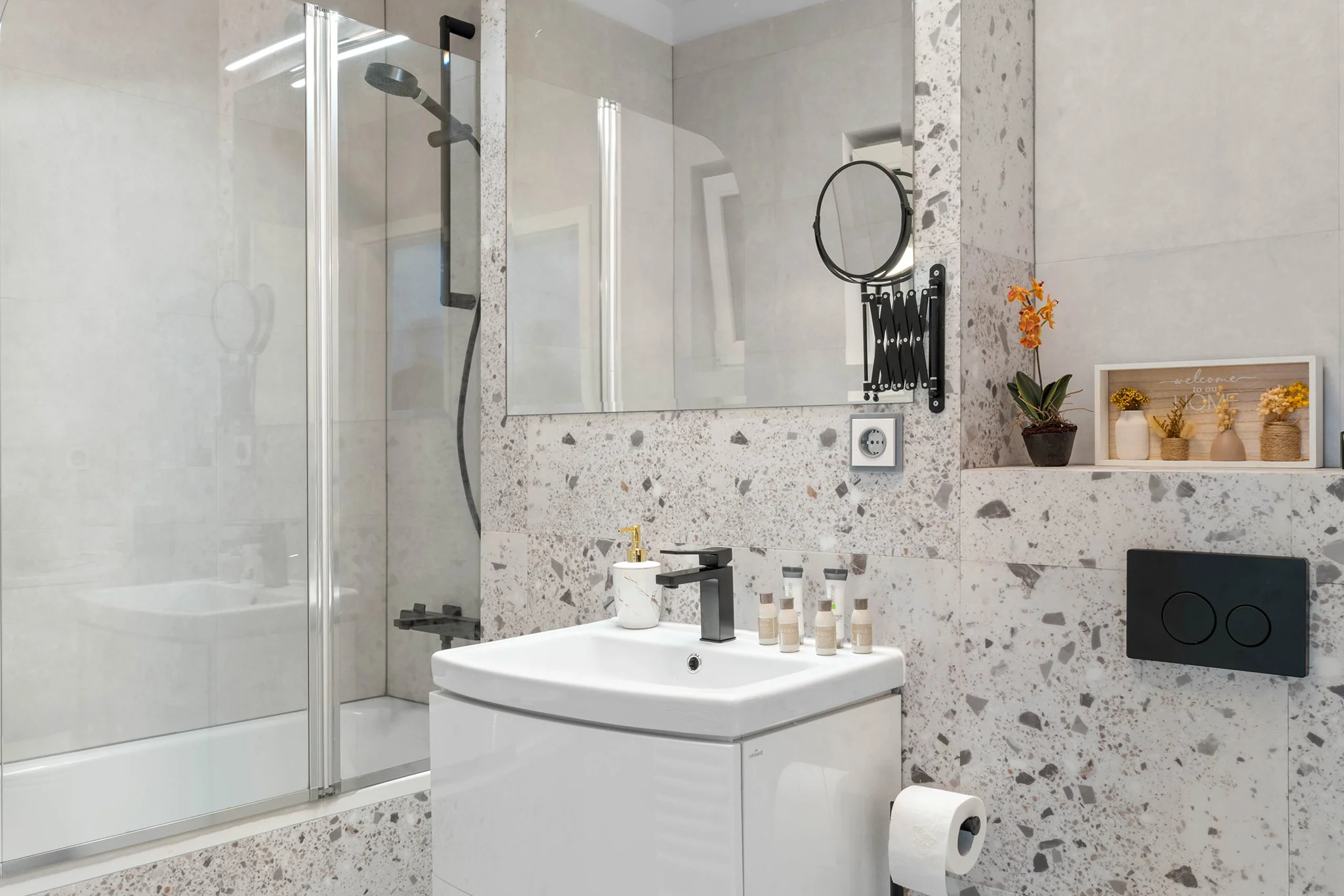 Modern bathroom with shower, sink, and decorative plants