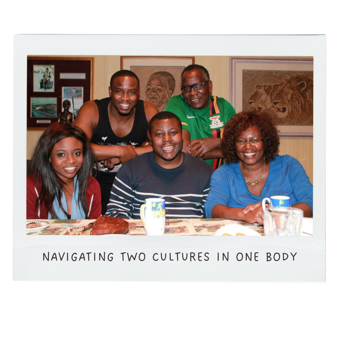 Group of five diverse people smiling around a table with cups and food, with framed artwork on the wall behind them.