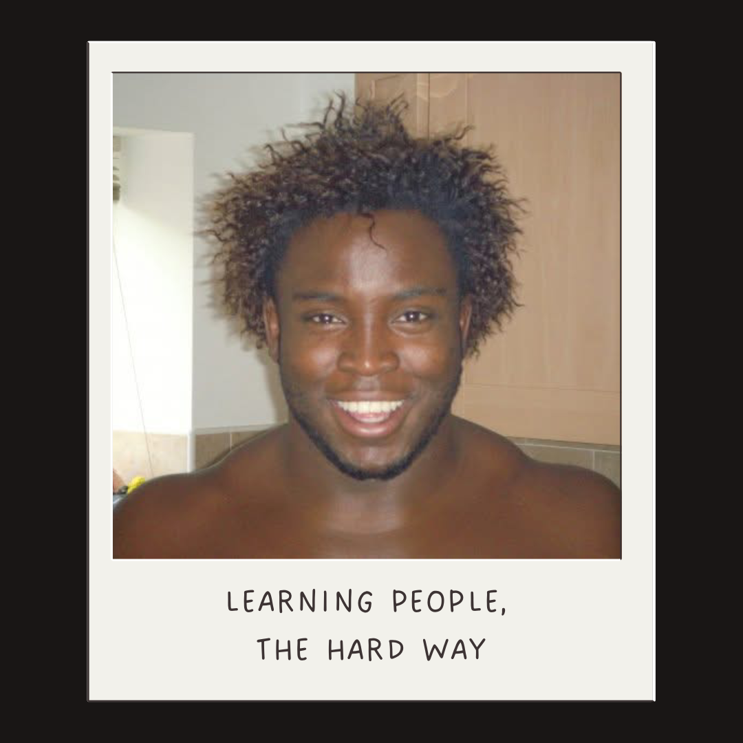 A smiling man with curly hair and a beard, shirtless, in a bathroom. The photo has a white border with handwritten text at the bottom that says "Learning people, the hard way."