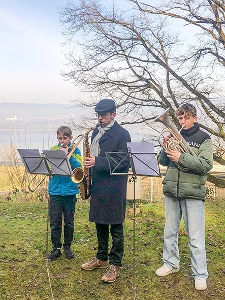 Adrian Knaup und Schüler der Musikschule Wettingen spielen Saxophon am See.