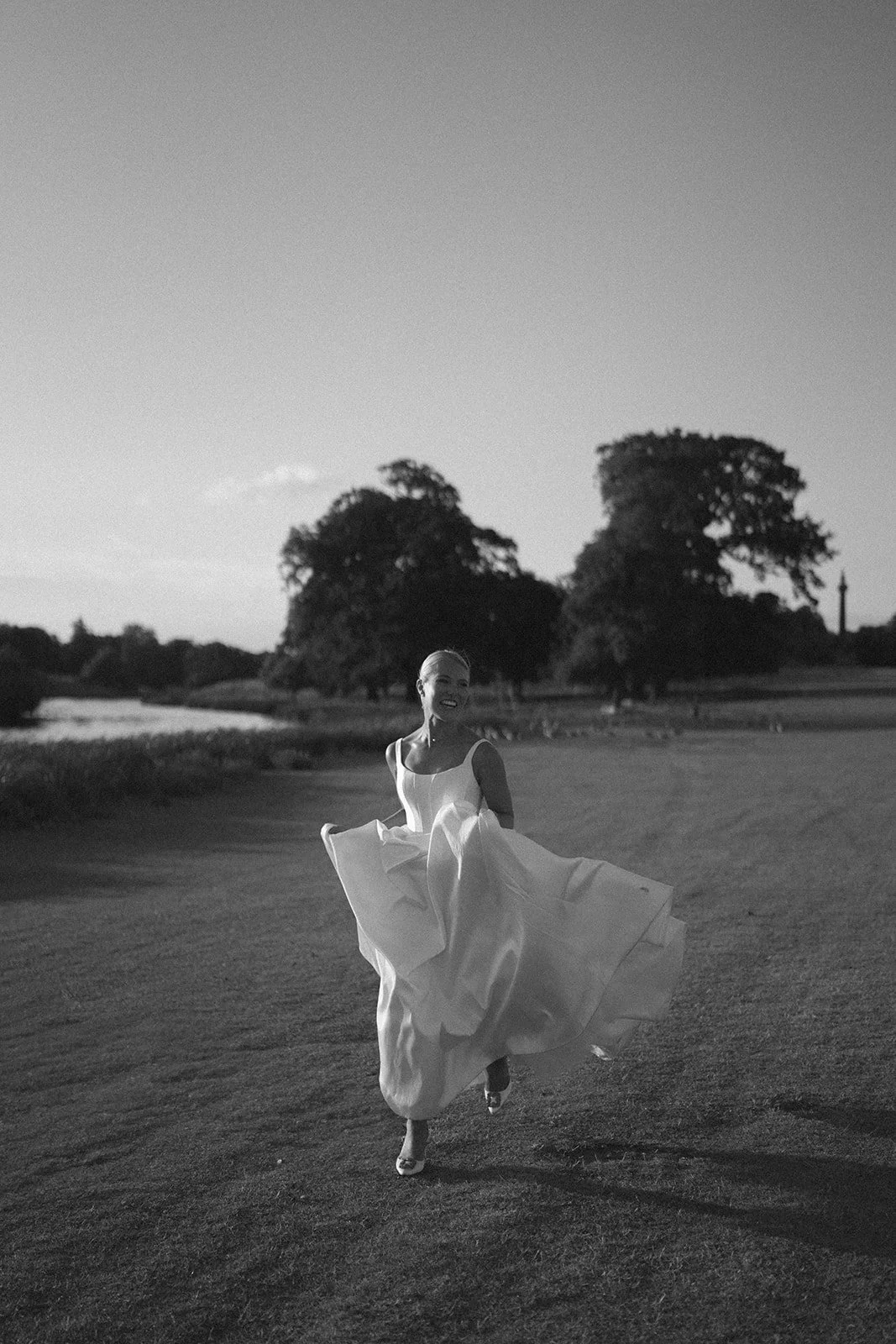 sail-and-peg-norfolk-holkham-hall-editorial-bride-running-lakeside-editorial-portrait-bw..jpg