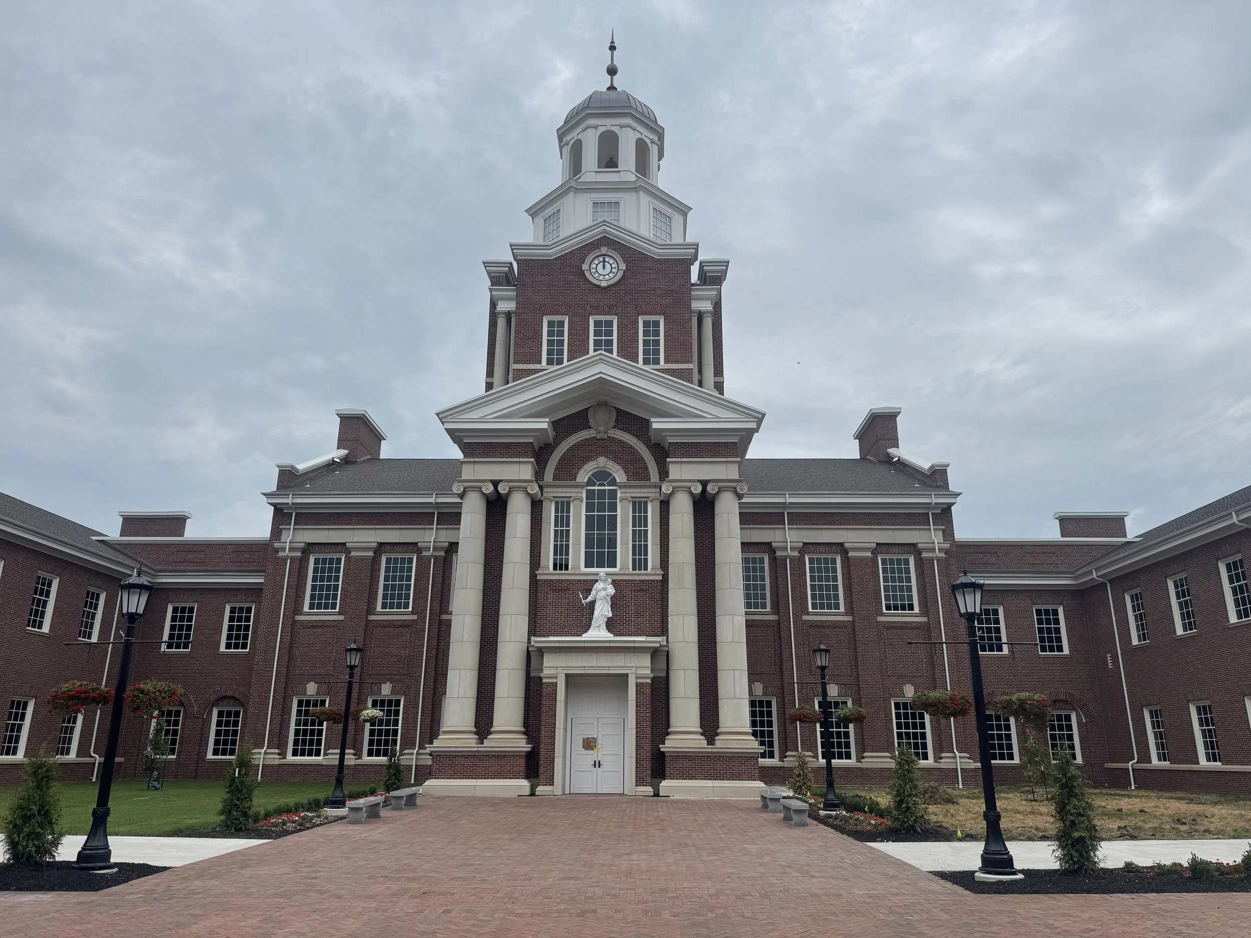 01 - Benedictine College Library

Category:  College & University

Description
Cast stone appears throughout this campus library in the entry surrounds, columns, sills, clock surrounds, pilaster caps, and banding. The entry and column work gives the 
