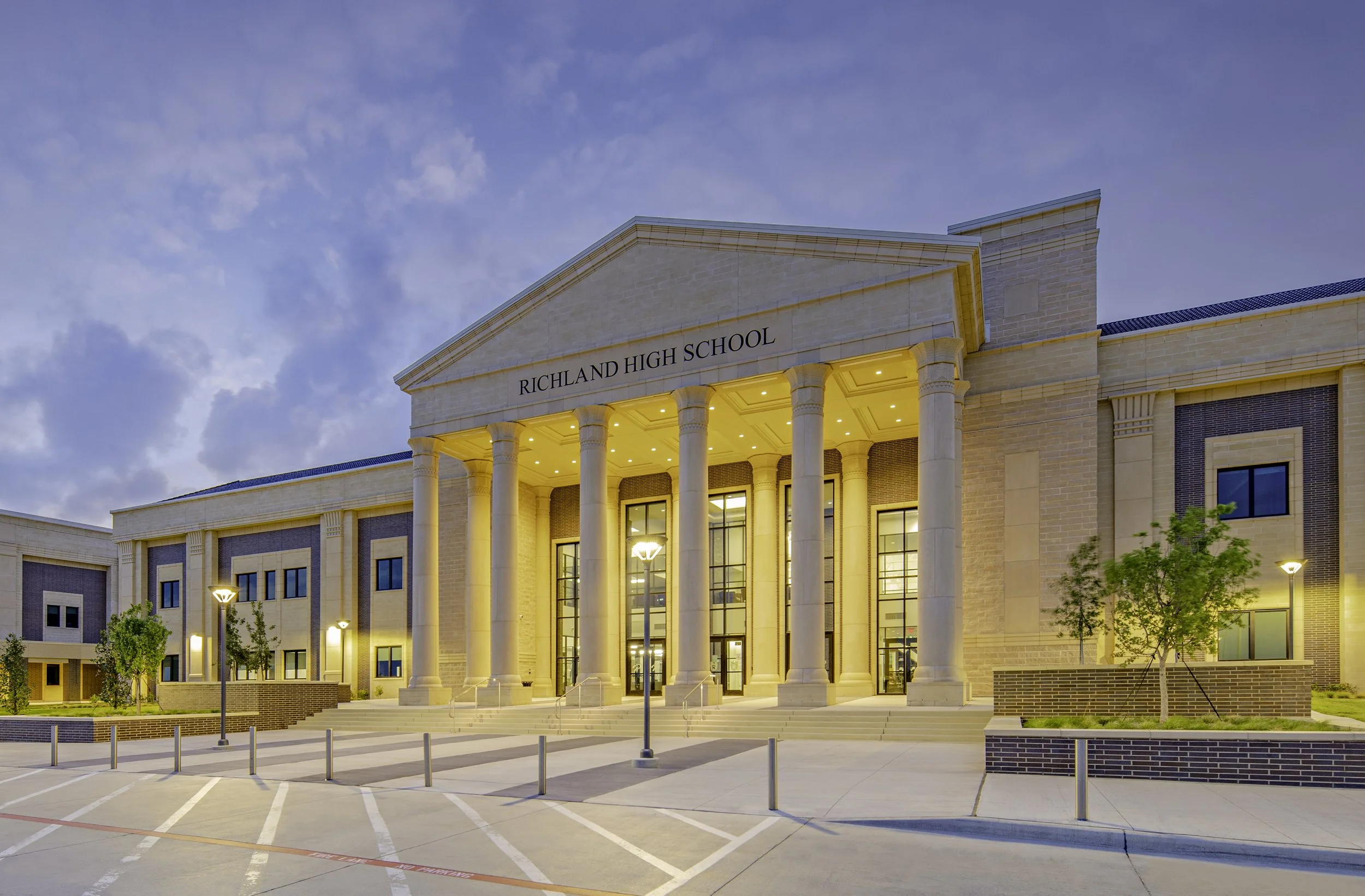 Massive Olympic style capitals and cast stone window trim across a 626,626 square foot high school. A 2026 Cast Stone Excellence Awards entry.