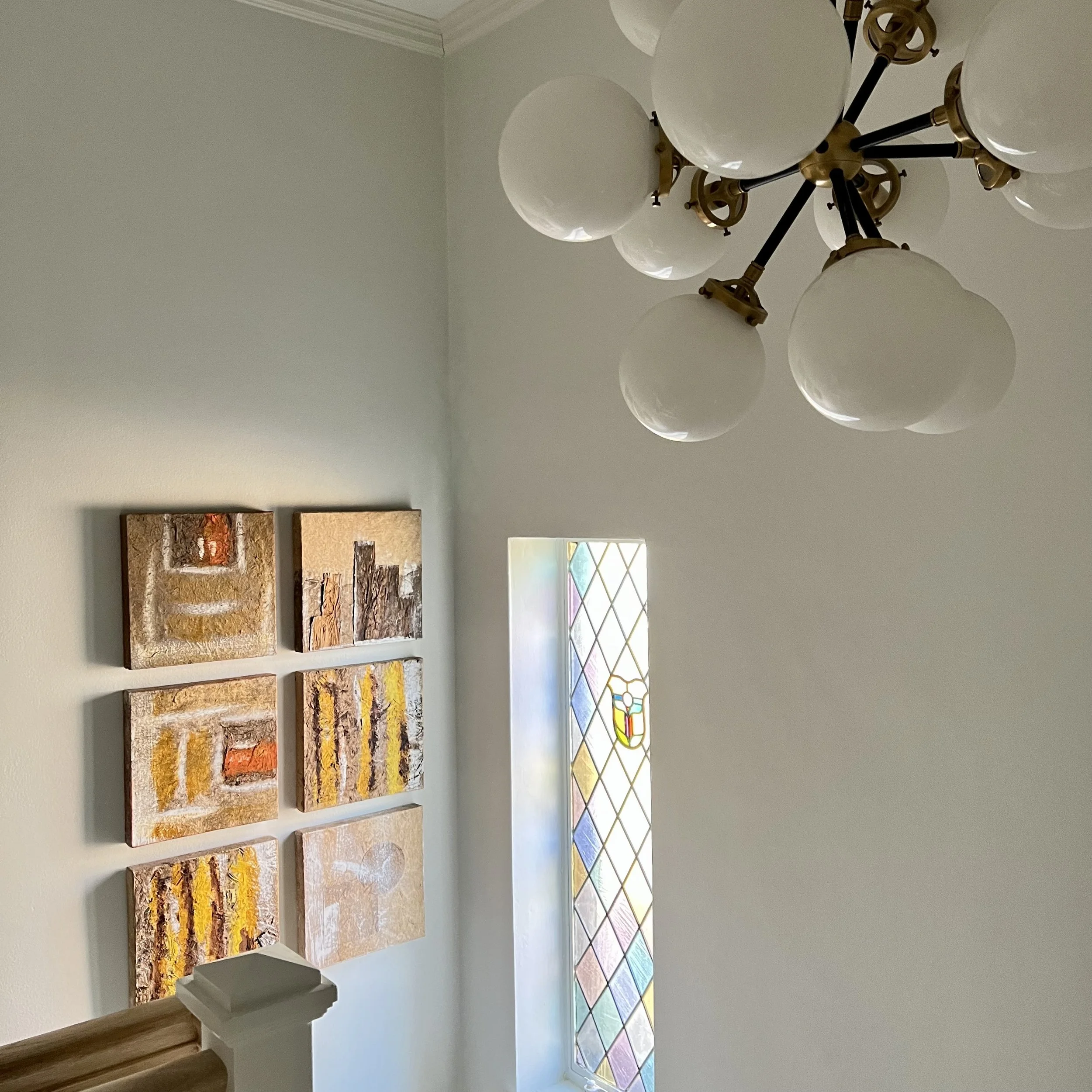 Interior of a staircase with abstract art and stained glass window