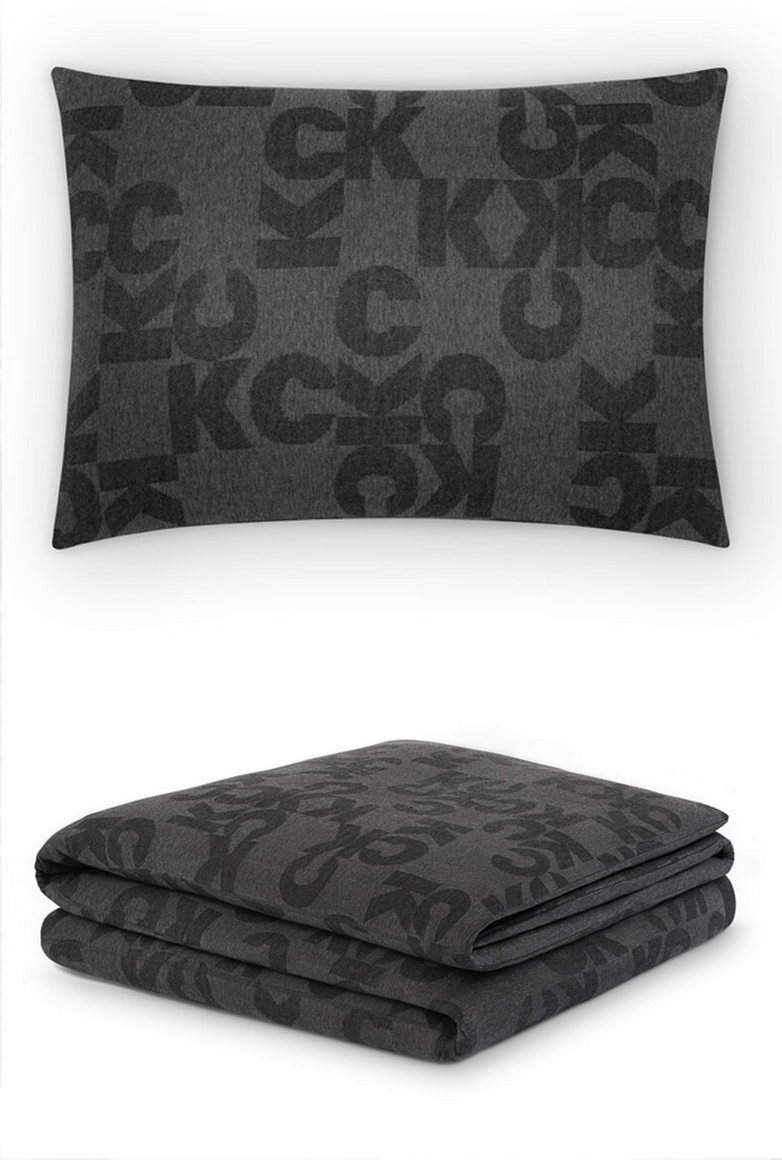 A dark gray pillow and blanket set with a black alphabet pattern.