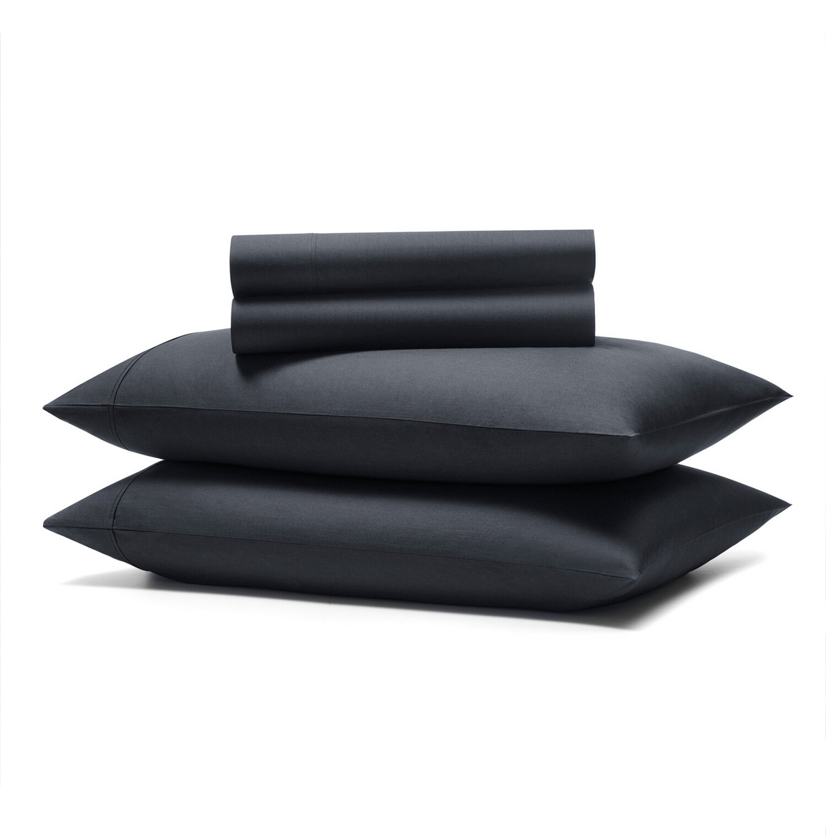 Two stacked black pillows with a rolled-up black cloth or blanket resting on top, against a plain white background.