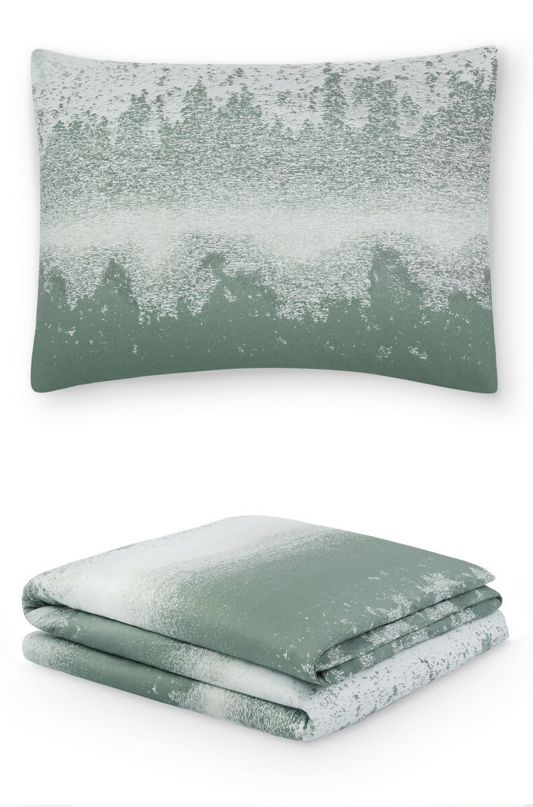 A green and white bedding set with a pillow and folded duvet or blanket, featuring a textured, abstract pattern.