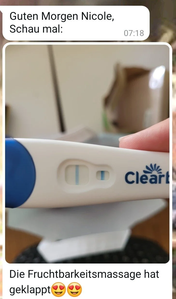 Schwangerschaftstest mit zwei Linien, Symbol für positive Schwangerschaft, gehalten in einer Hand vor einem Raumhintergrund.