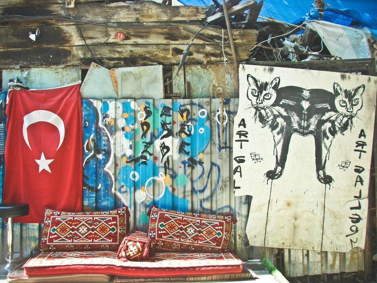 “A vibrant corner of a Turkish village with traditional carpets, bold street art, and a Turkish flag — where heritage and soul meet.”