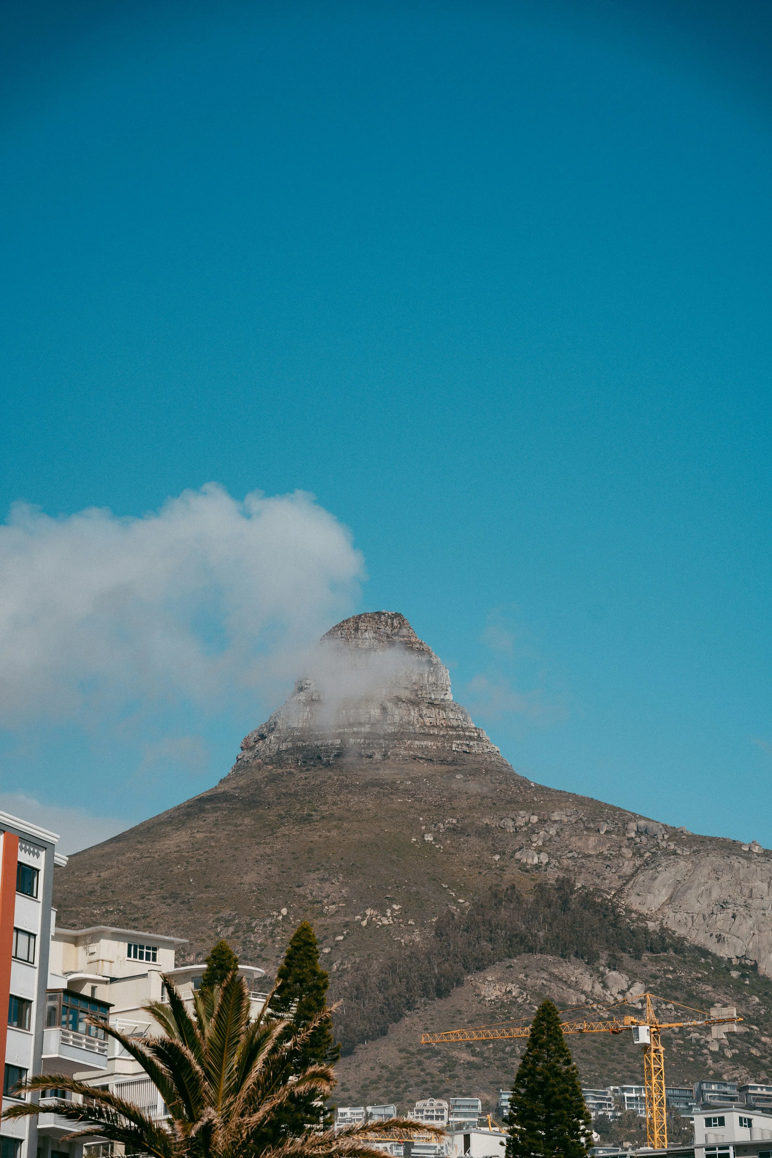 “Lion’s Head mountain under a soft cloud in Cape Town, viewed from a quiet neighborhood — a symbol of calm and stillness.”