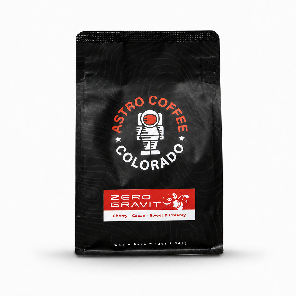 A black package of Zero Gravity coffee from Astro Coffee Colorado, flavor cherry cacao, labeled as sweet & creamy, with a graphic of an astronaut and a cherry.