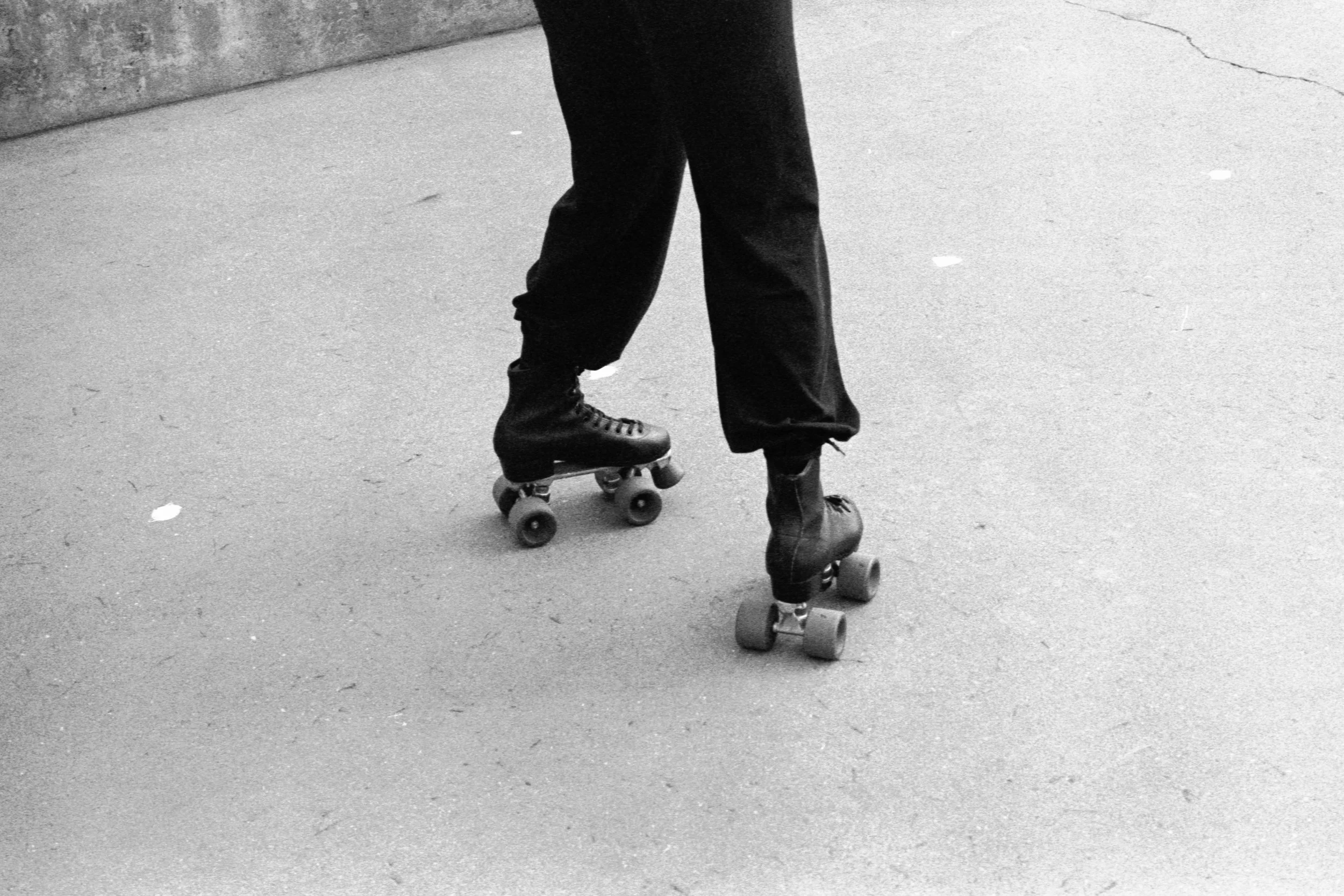 Persona patinando en línea en una superficie de concreto.