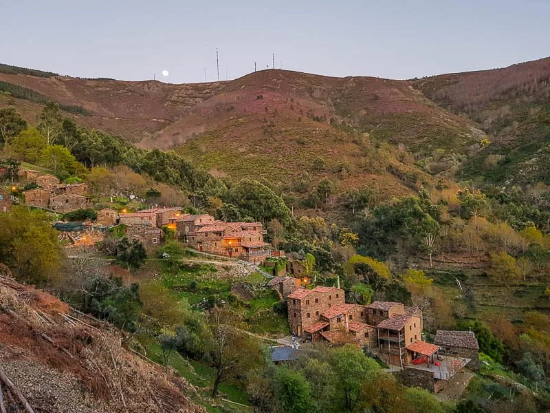 Stone houses of a schist village on a green hillside in the mountains of central Portugal