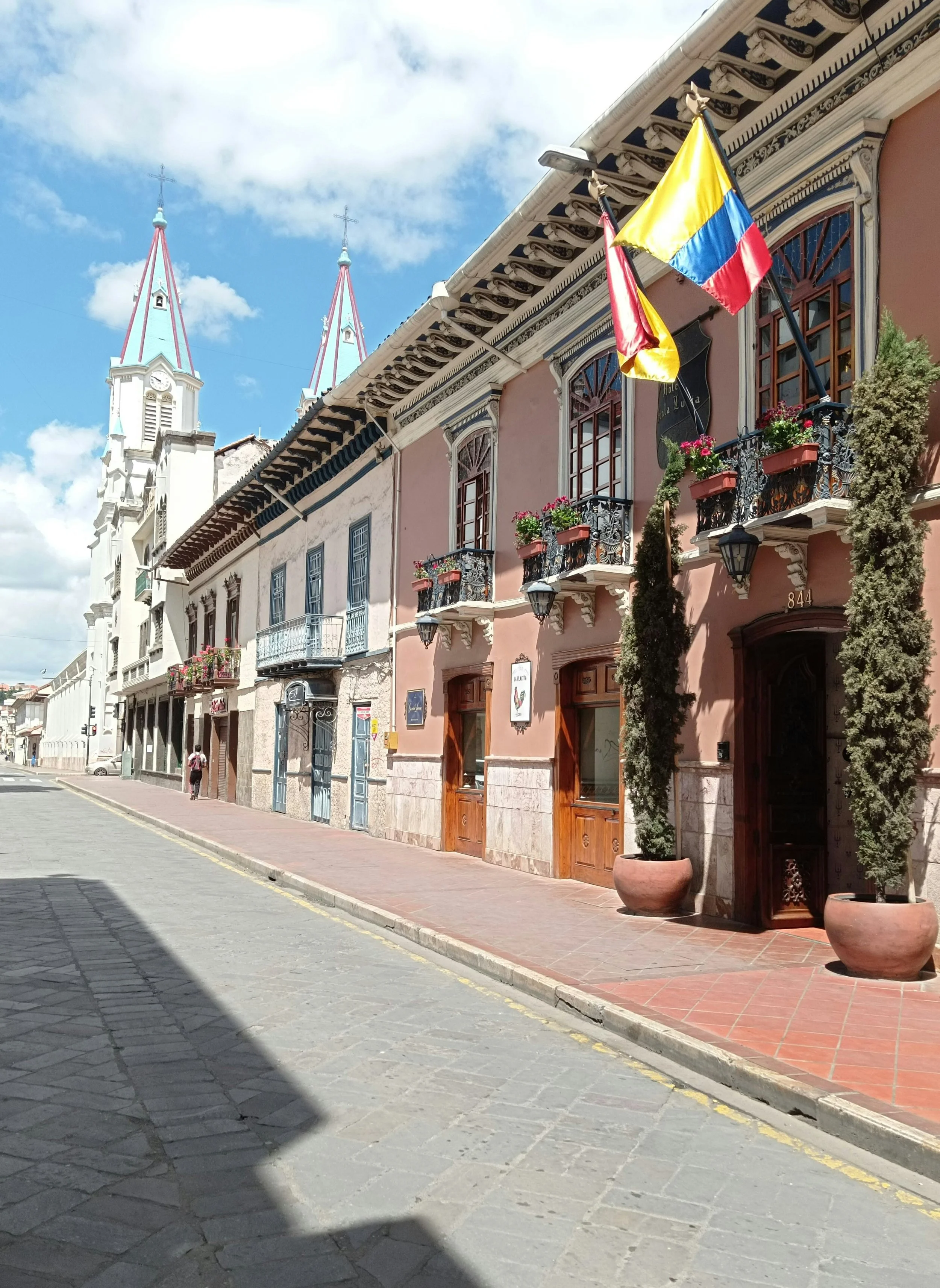 Colonial street with a white church and Ecuadorian flags in Ecuador