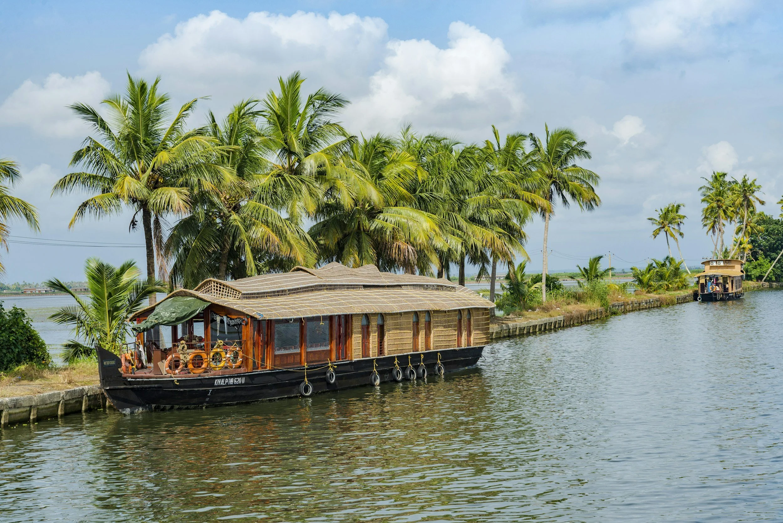 A traditional houseboat on the palm-lined backwaters of Kerala, South India.