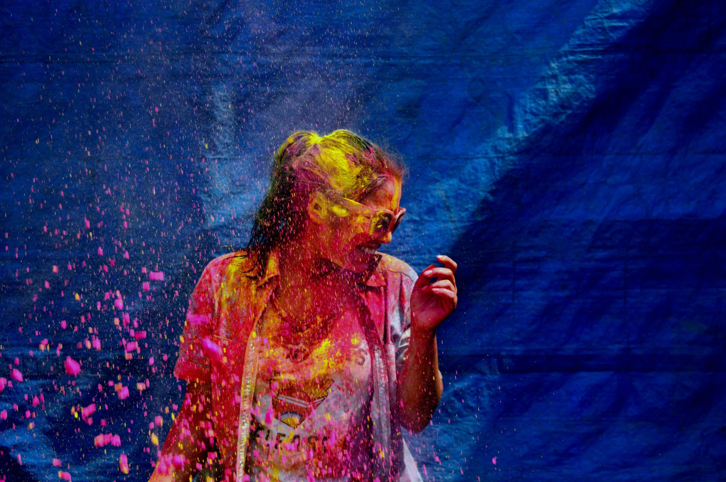 Woman covered in bright colored powder during Holi in India
