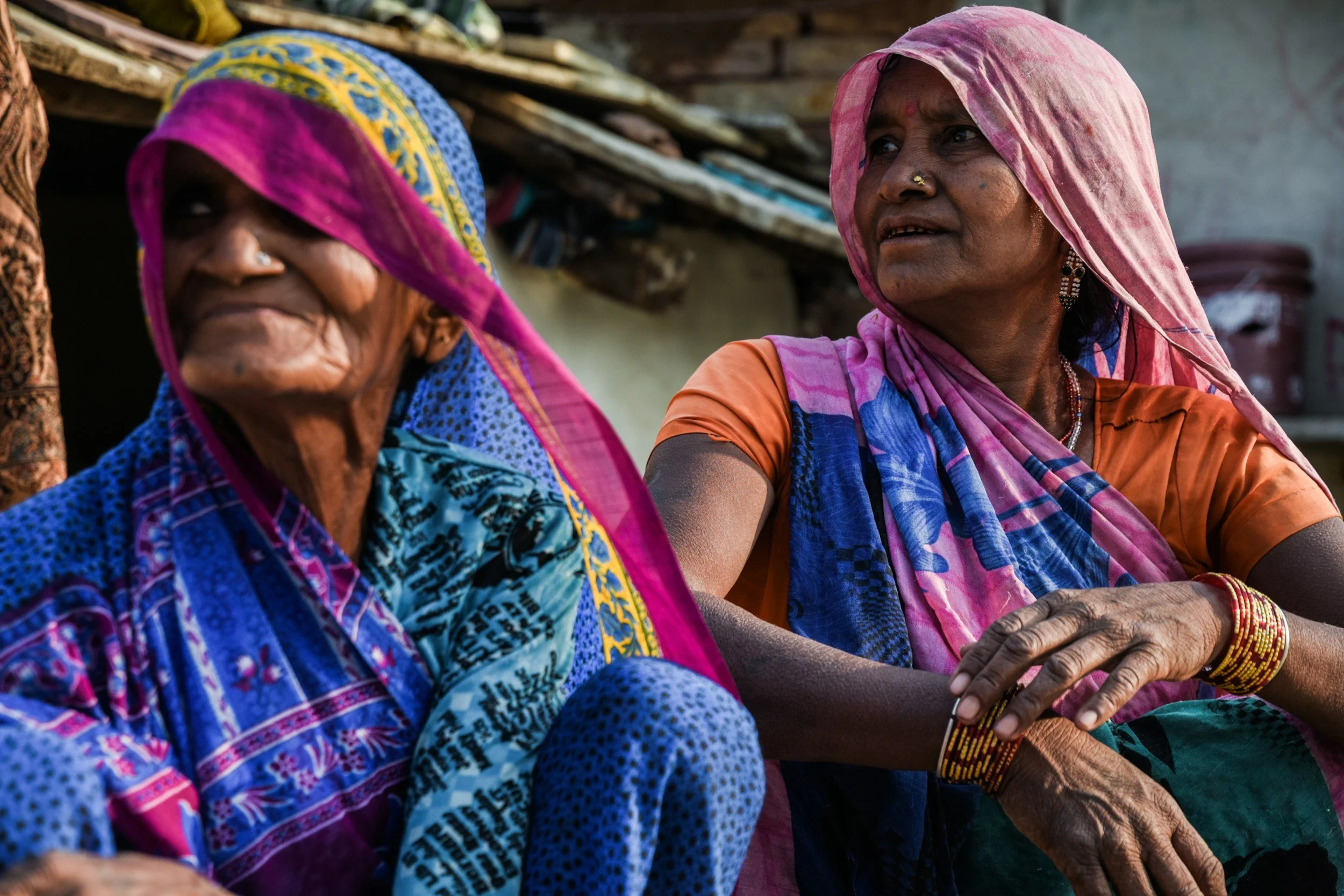 Two smiling women in colorful saris and headscarves in India.