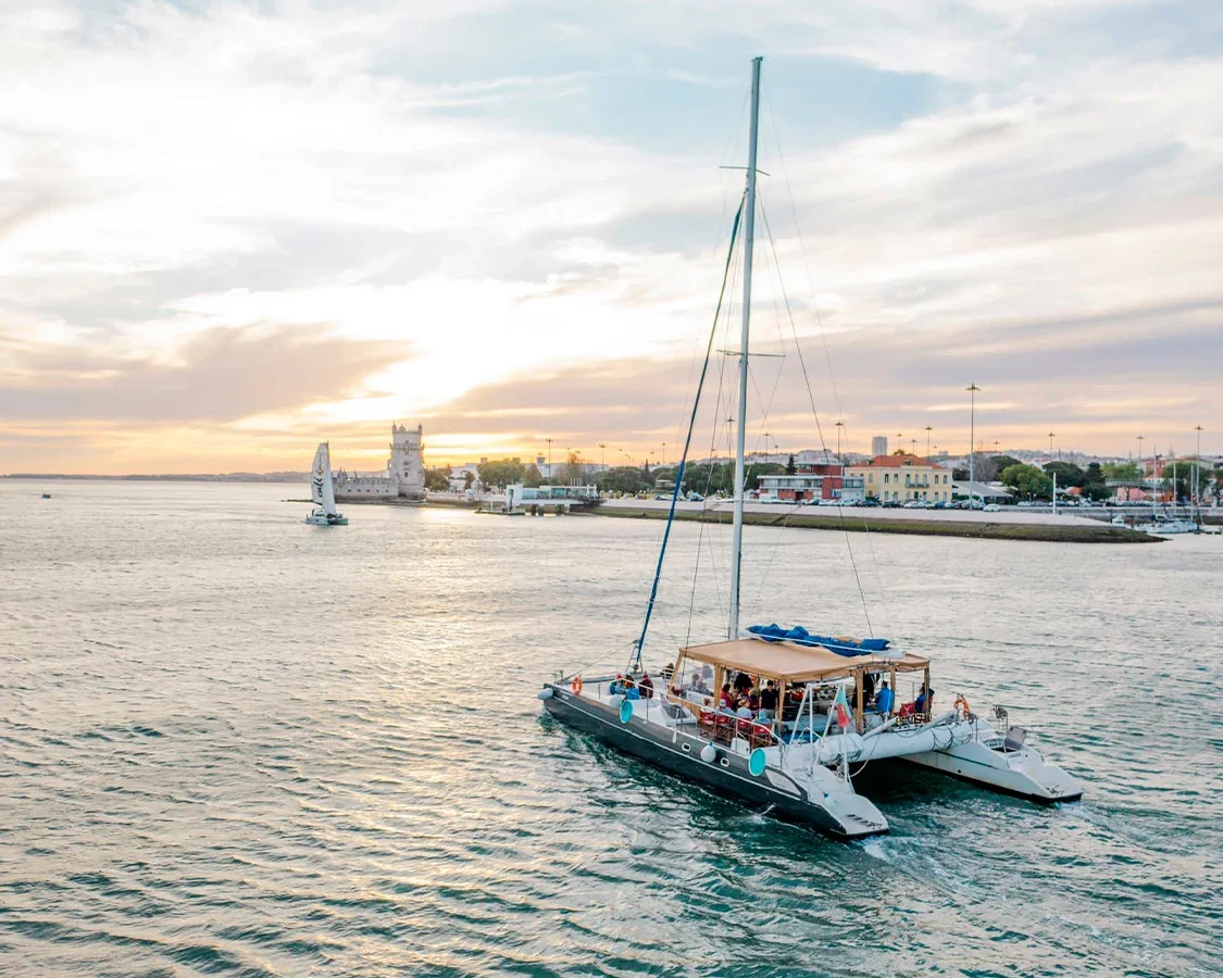 Catamaran sailing on the Tagus River in Lisbon at sunset