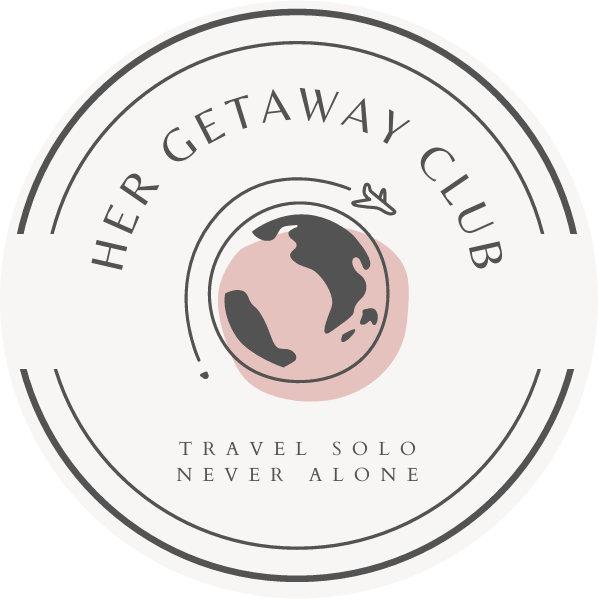 Circular logo with a globe and airplane illustration, surrounded by the text 'Her Getaway Club' and the slogan 'Travel Solo Never Alone'.