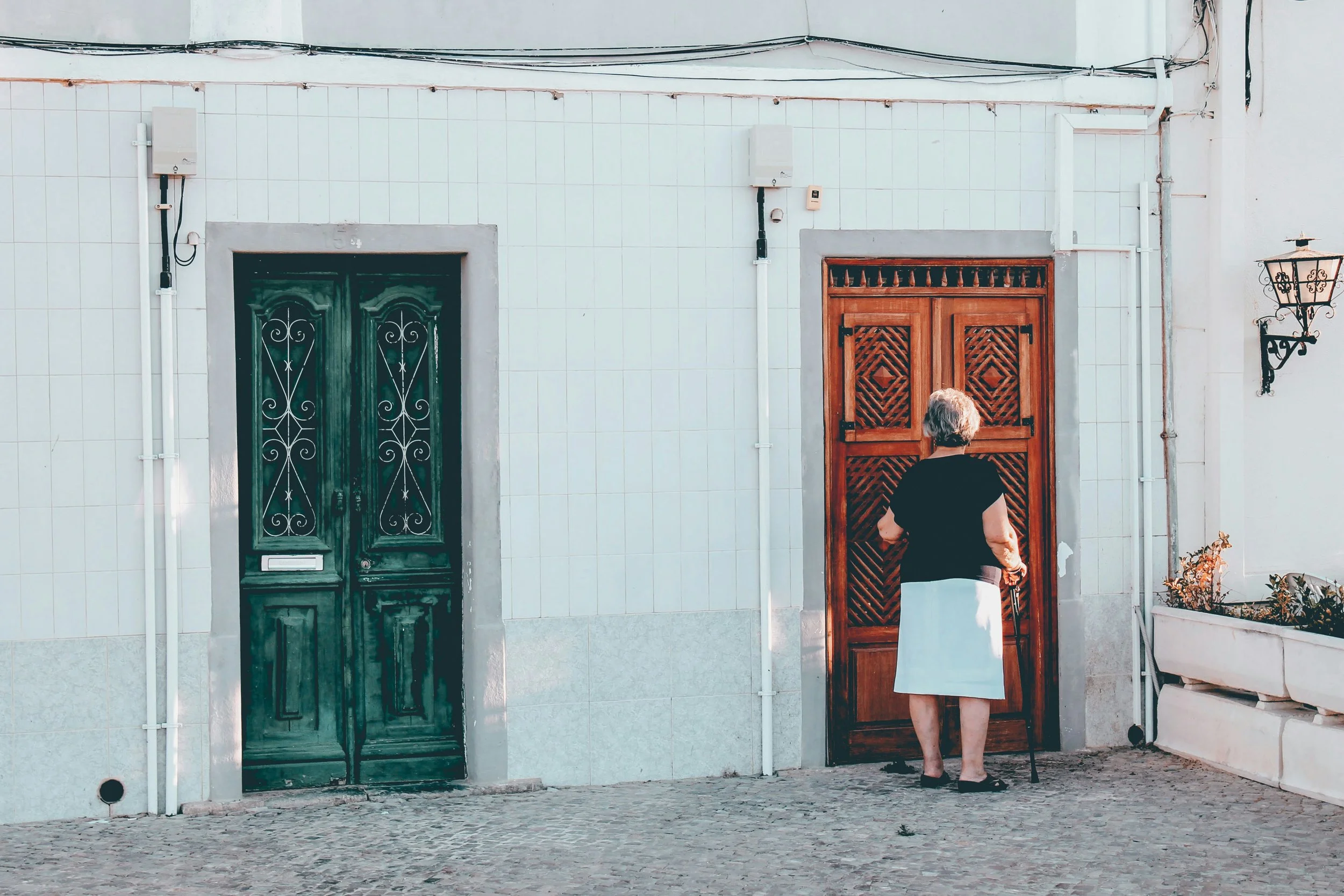 Woman exploring a quiet Lisbon street lined with colorful doors