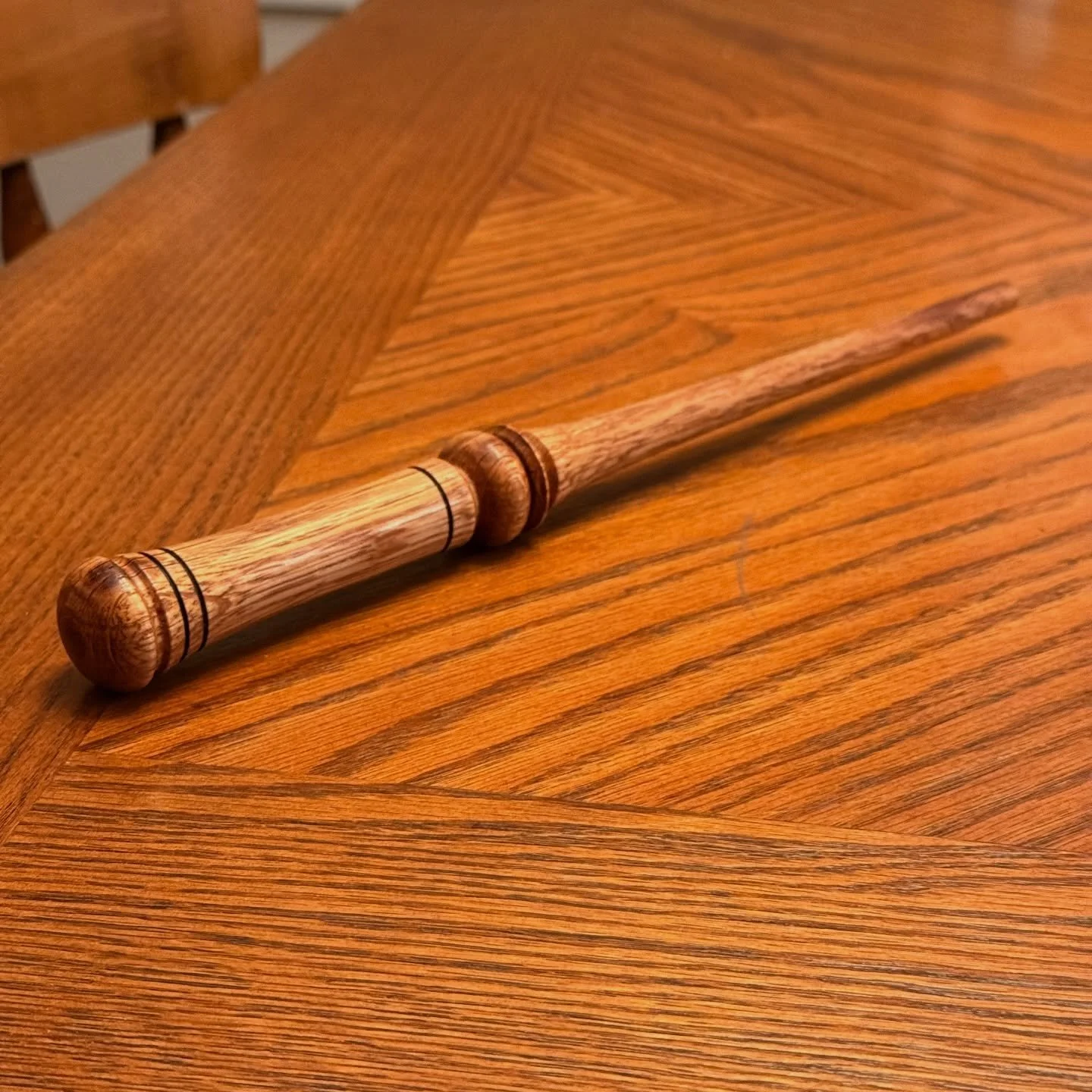 +7 INT ✨
First attempt at a wand. Turned on the lathe from oak.

You can come find this one (and others like it) at the South Medford High Vendor Fair
📍 April 18
⏰ 10am &ndash; 7pm