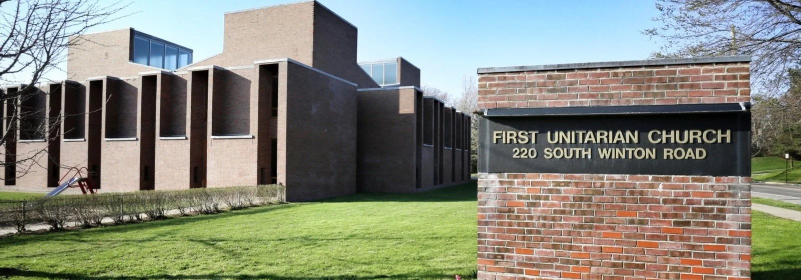 a photo of the completed building featuring the original brick road sign reading First Unitarian Church 220 South Winton Road
