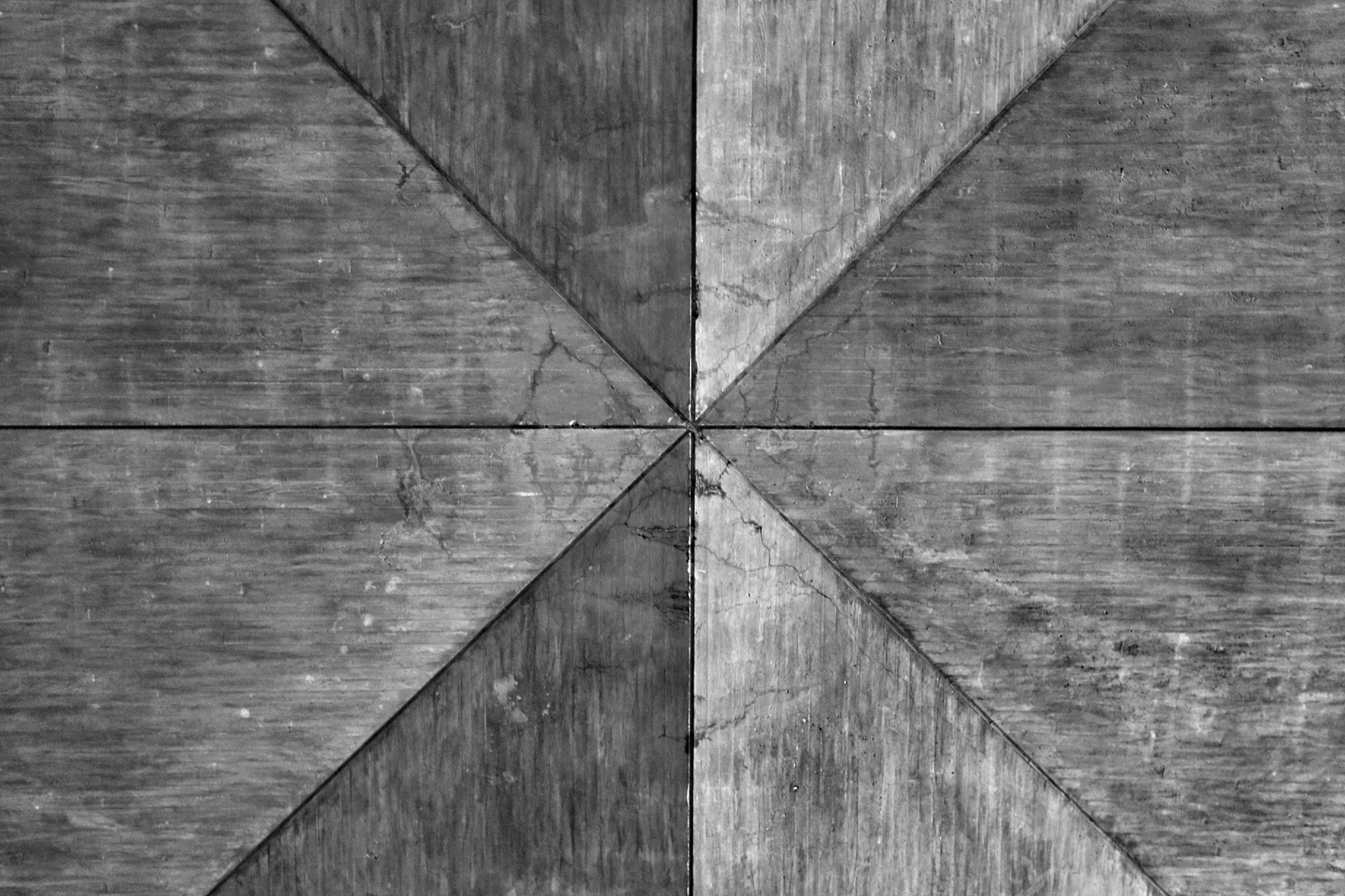 A ceiling with a geometric pattern of wooden beams forming a triangular shape.