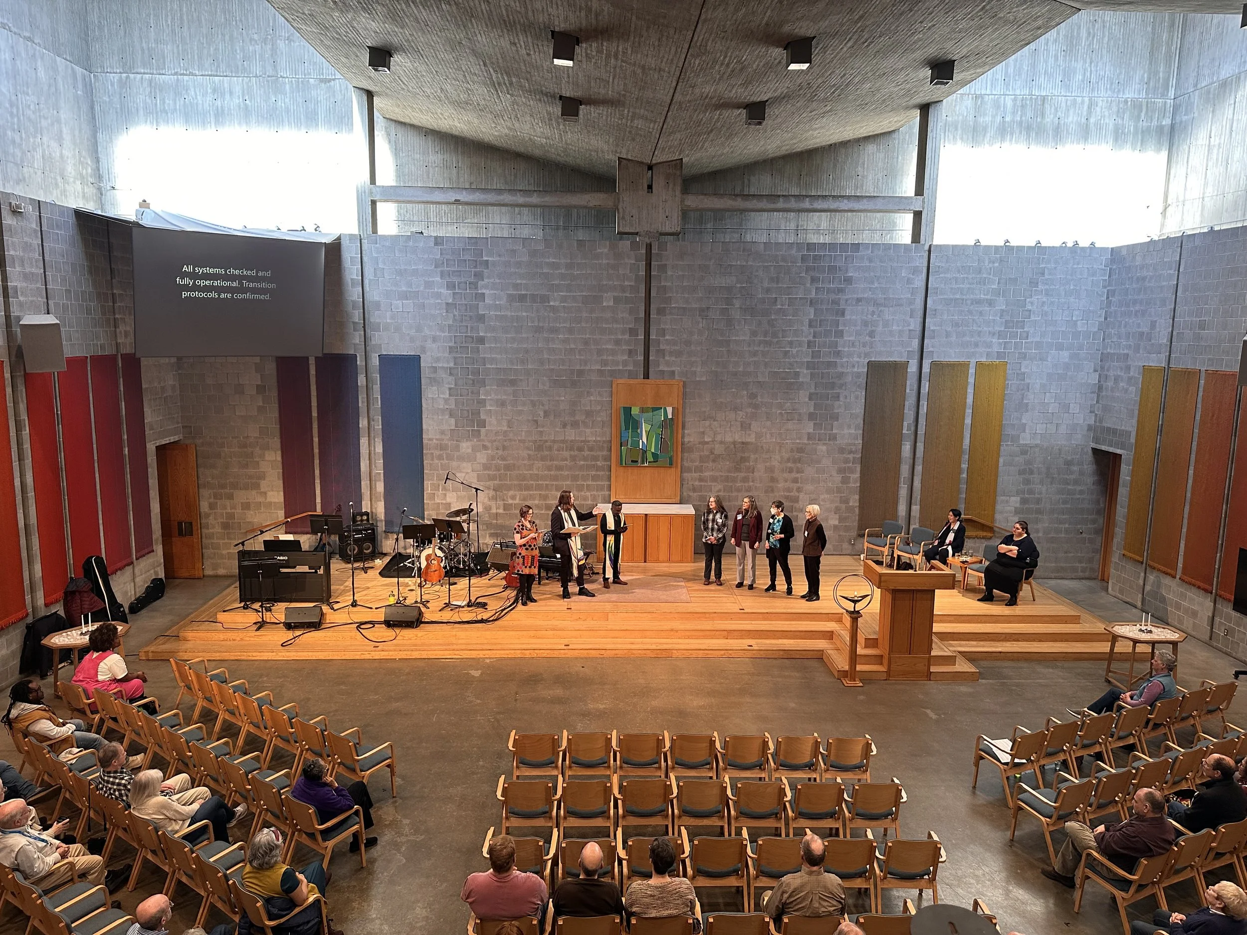 a photo taken from the choir loft showing many people during a worship service