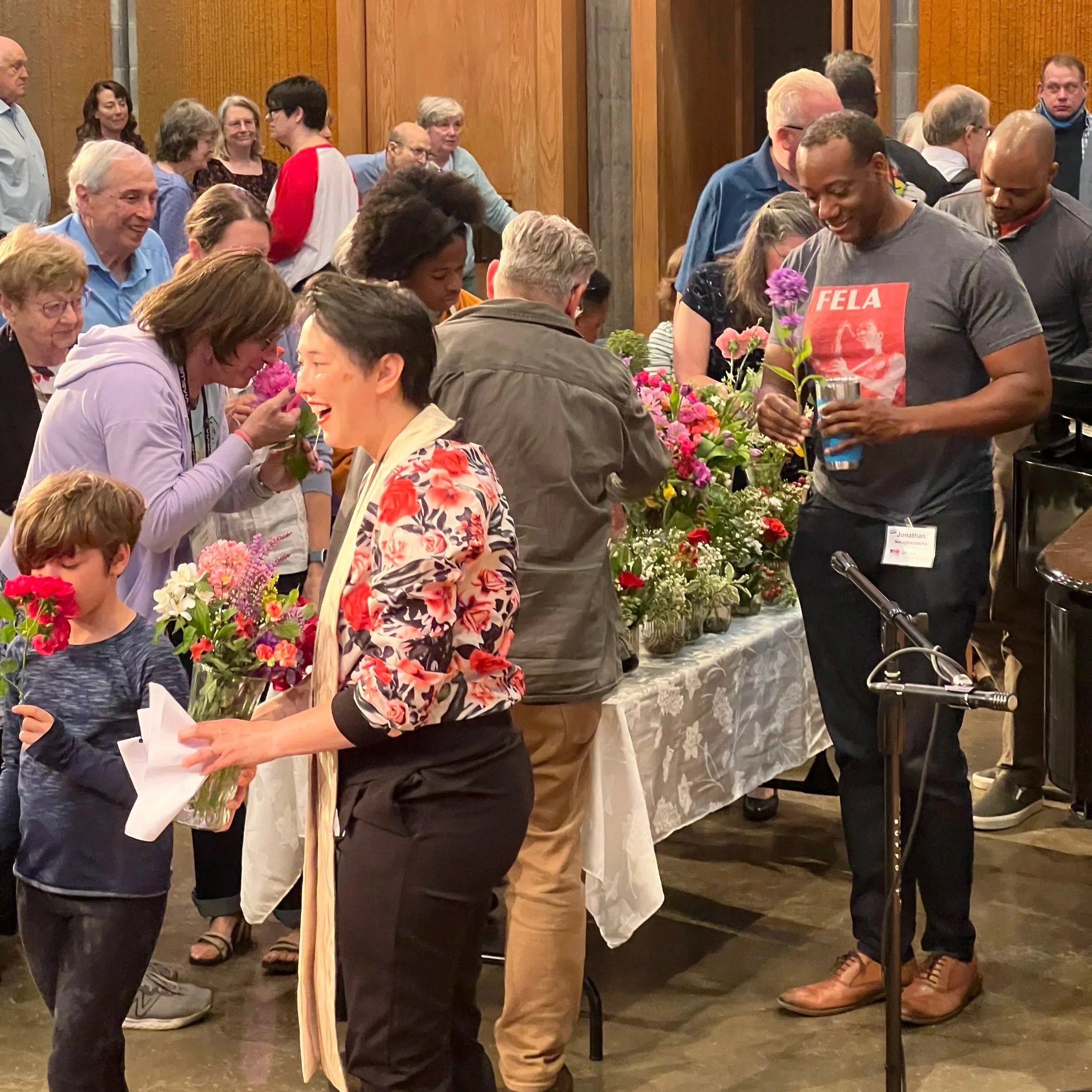 Children and adults choose flowers from tables at the front of the sanctuary during Flower Sunday.