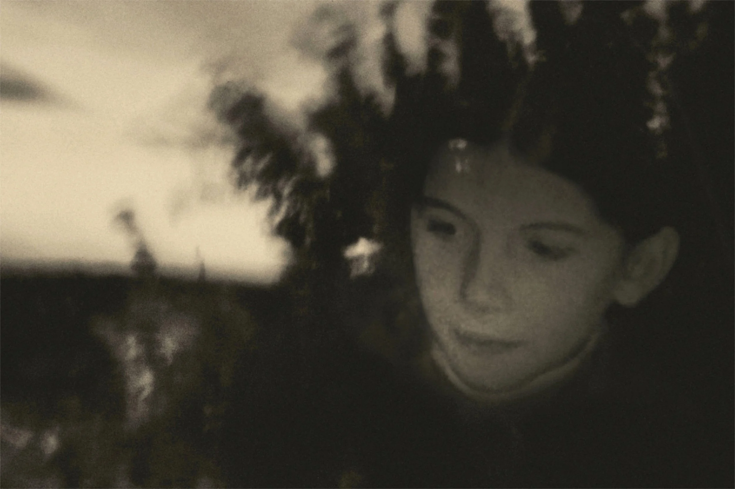 Une colline ou une petite montagne rocheuse avec quelques arbres dénudés, photographiée en noir et blanc.