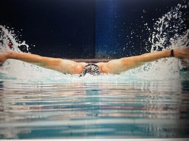 Swimmer learning butterfly stroke technique in swimming lesson.