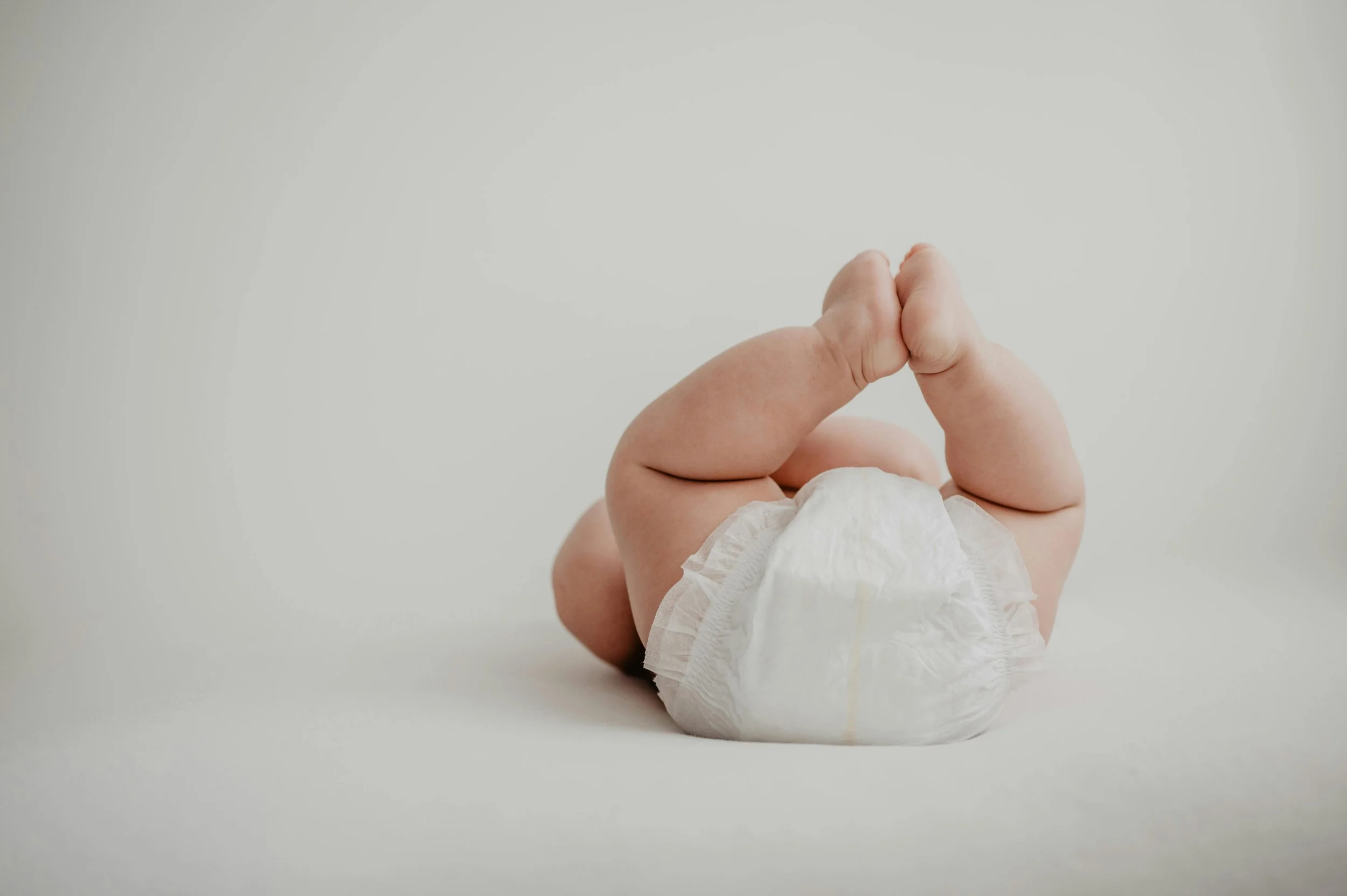 Infant experiencing first swimming lesson with parent in pool.