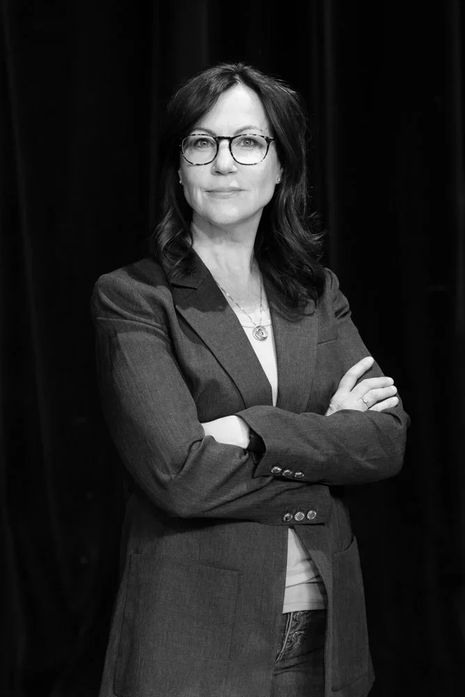 Michele Kreuzer, adult sleep coach, smiling confidently while crossing her arms.