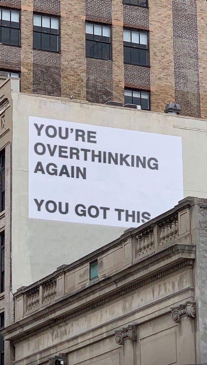 Building facade with a large sign saying "You're overthinking again, you got this."