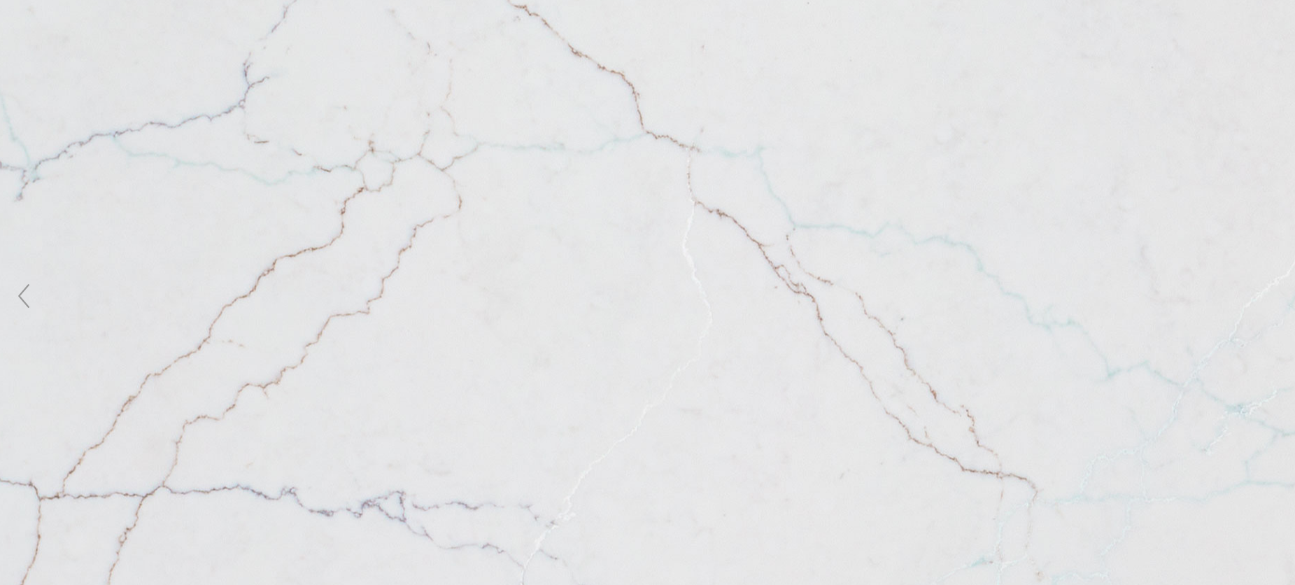 Close-up of white marble surface with subtle gray and brown veining.