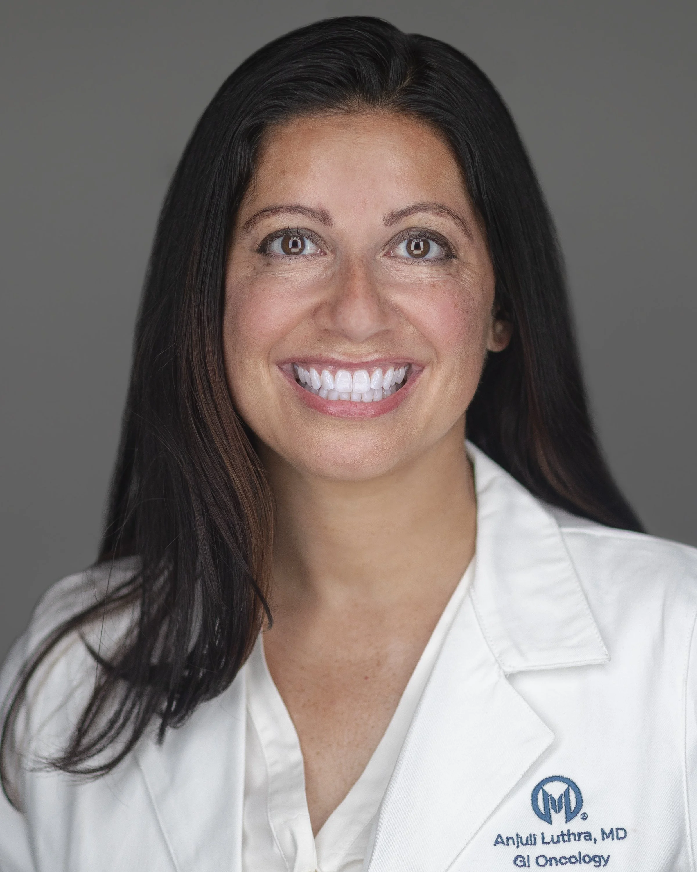 From above hands of unrecognizable woman rubbing aromatic spices into piece of raw meat over parchment paper