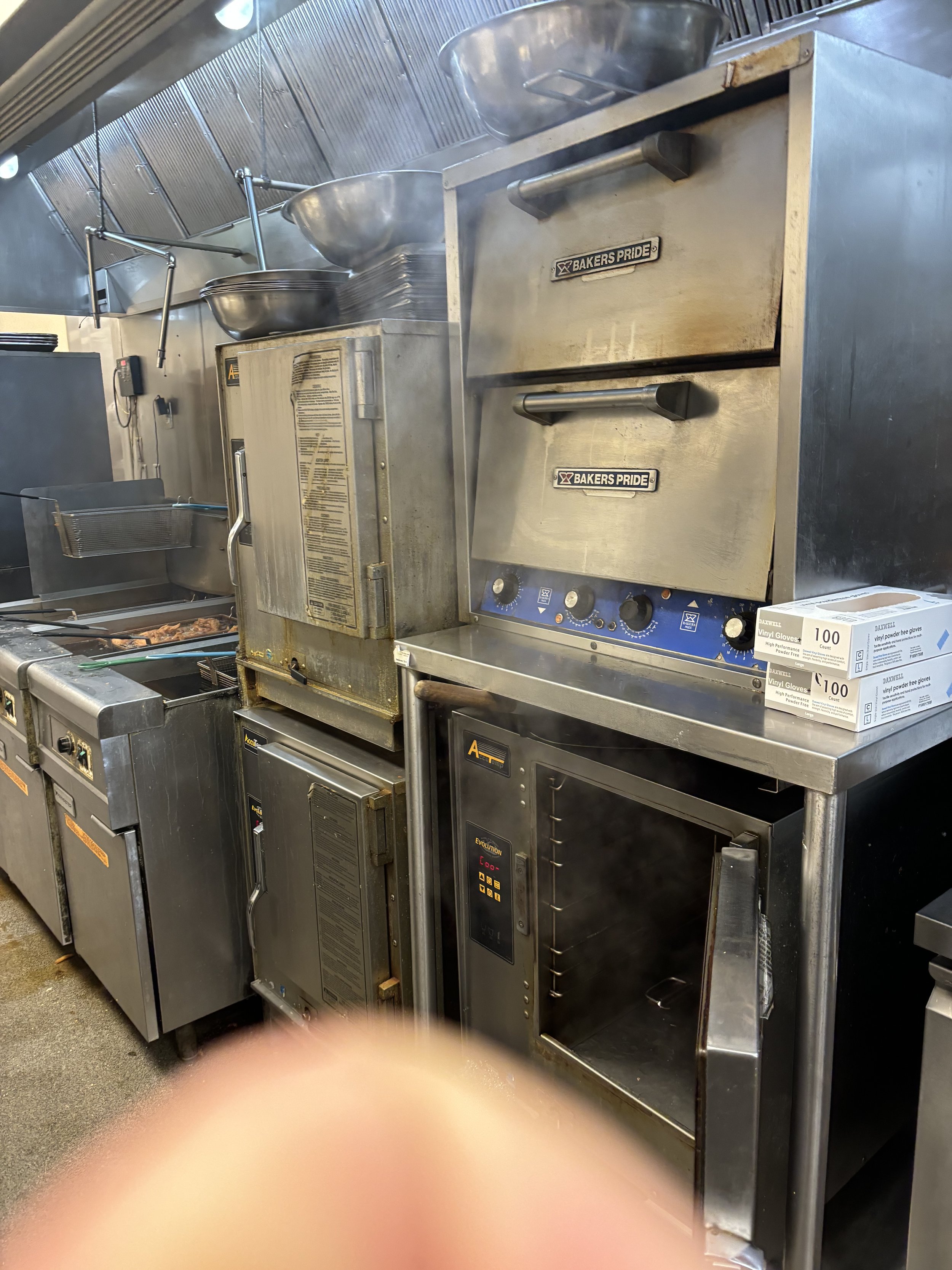 Commercial kitchen with ovens and stainless steel equipment.