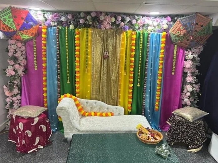 Colorful decorated stage setup with flowers and drapes